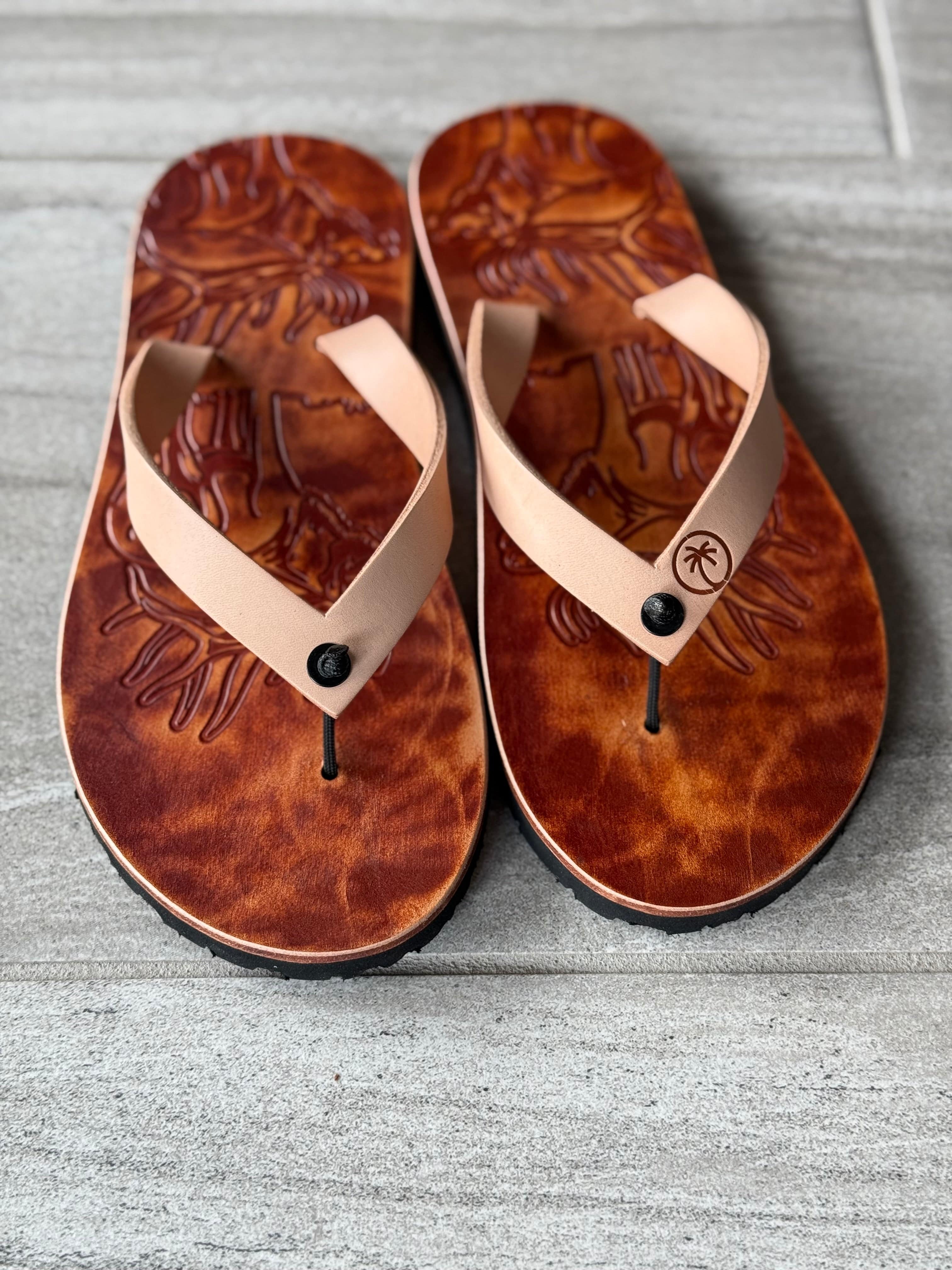 Toehold Bull Elk flip-flops with detailed elk head design on black straps and cushioned soles for comfortable summer wear