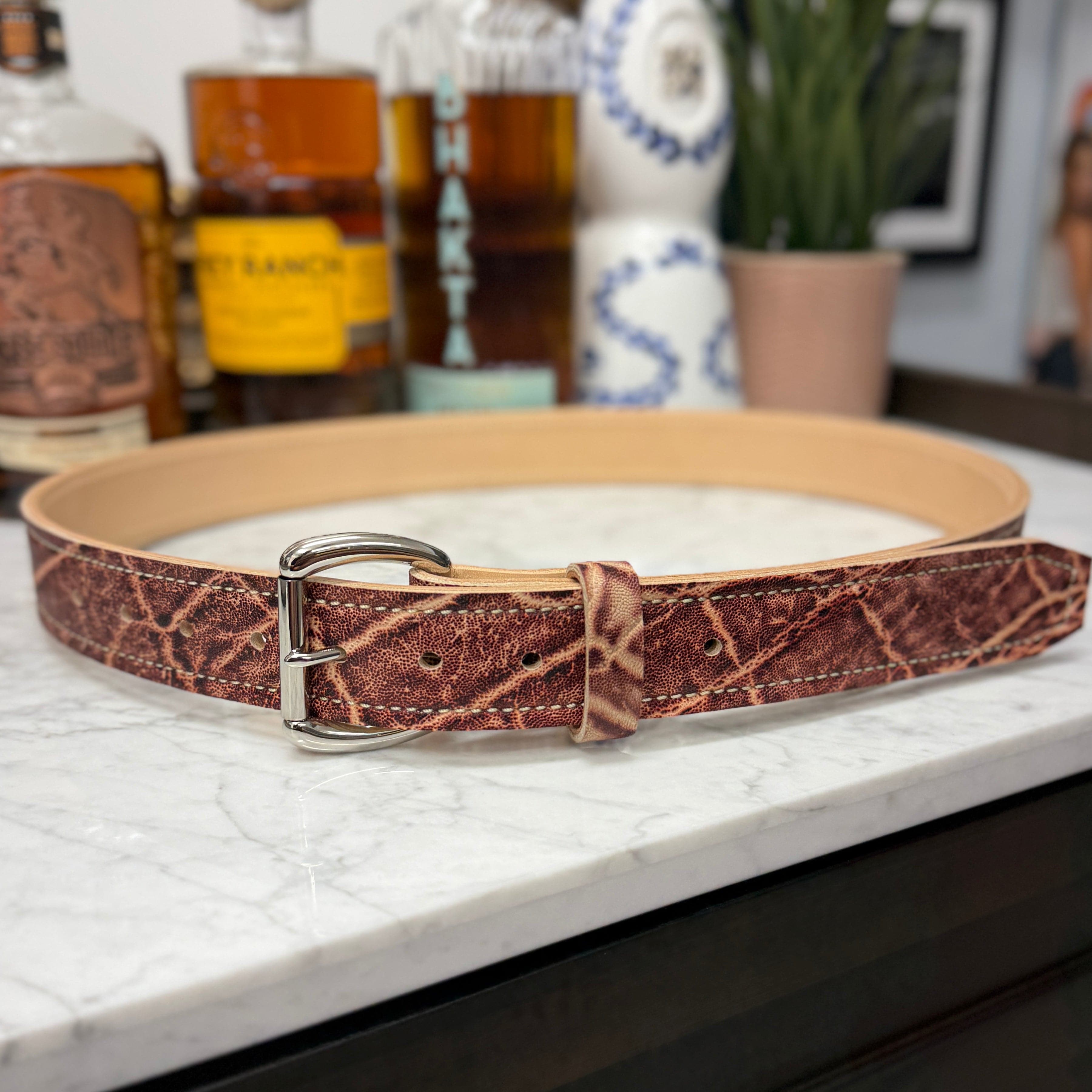Toehold Man Killing Elephant Belt showing a detailed leather belt with metal buckle and embossed elephant design
