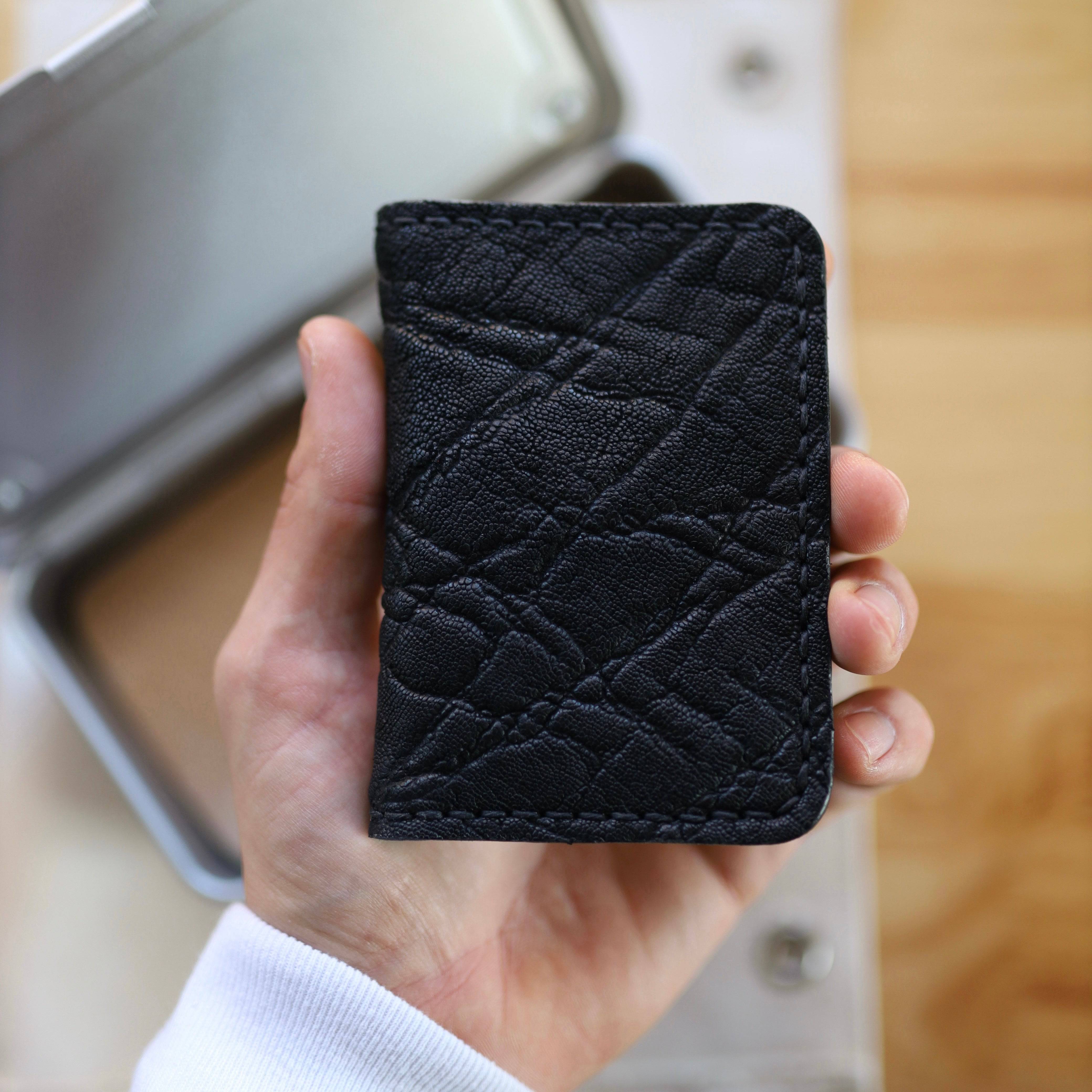 Black Elephant JW Wallet by Toehold featuring a sleek design and detailed elephant motif, shown on a neutral background.