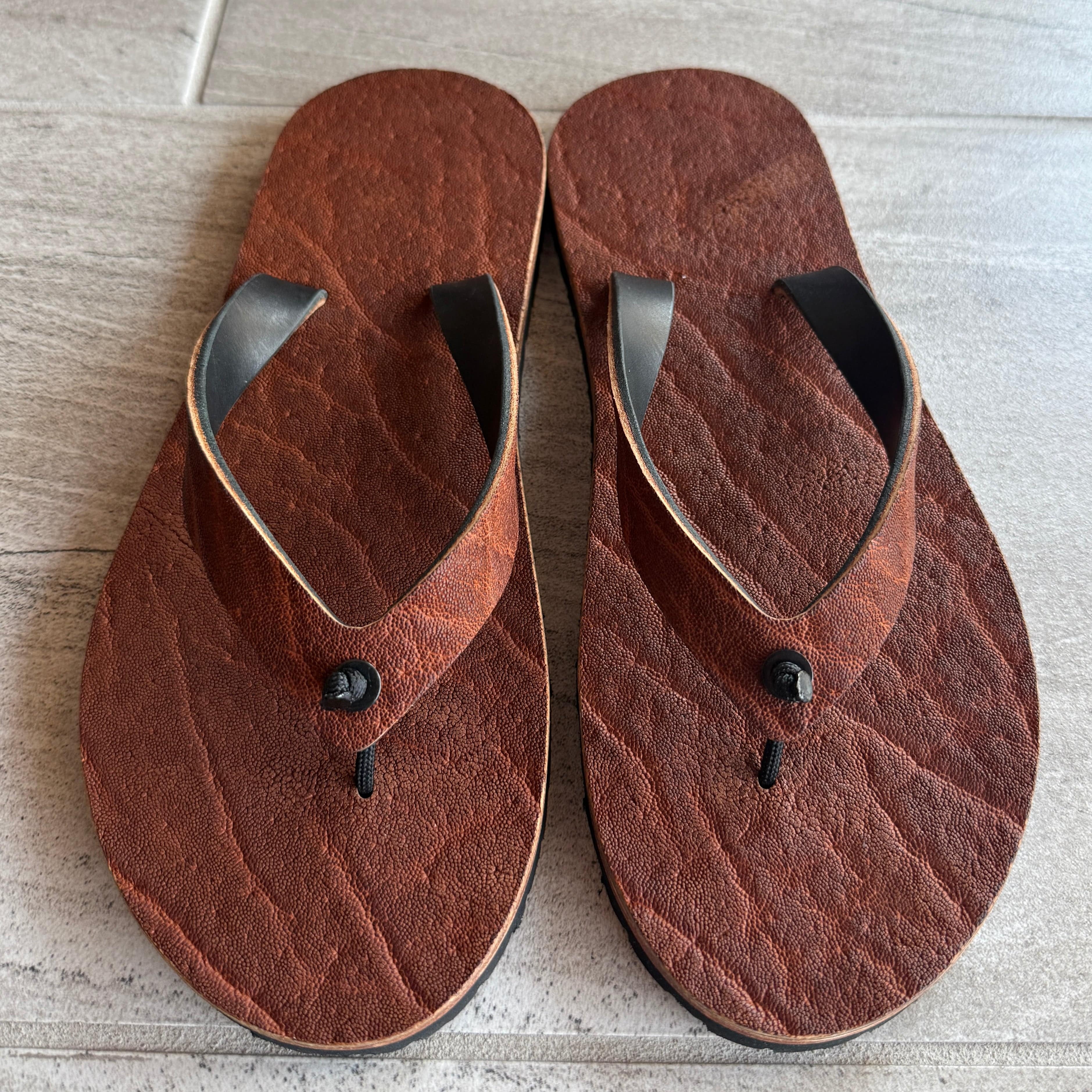 Toehold brown African elephant flip-flops with elephant-shaped design on the straps and comfortable rubber soles.