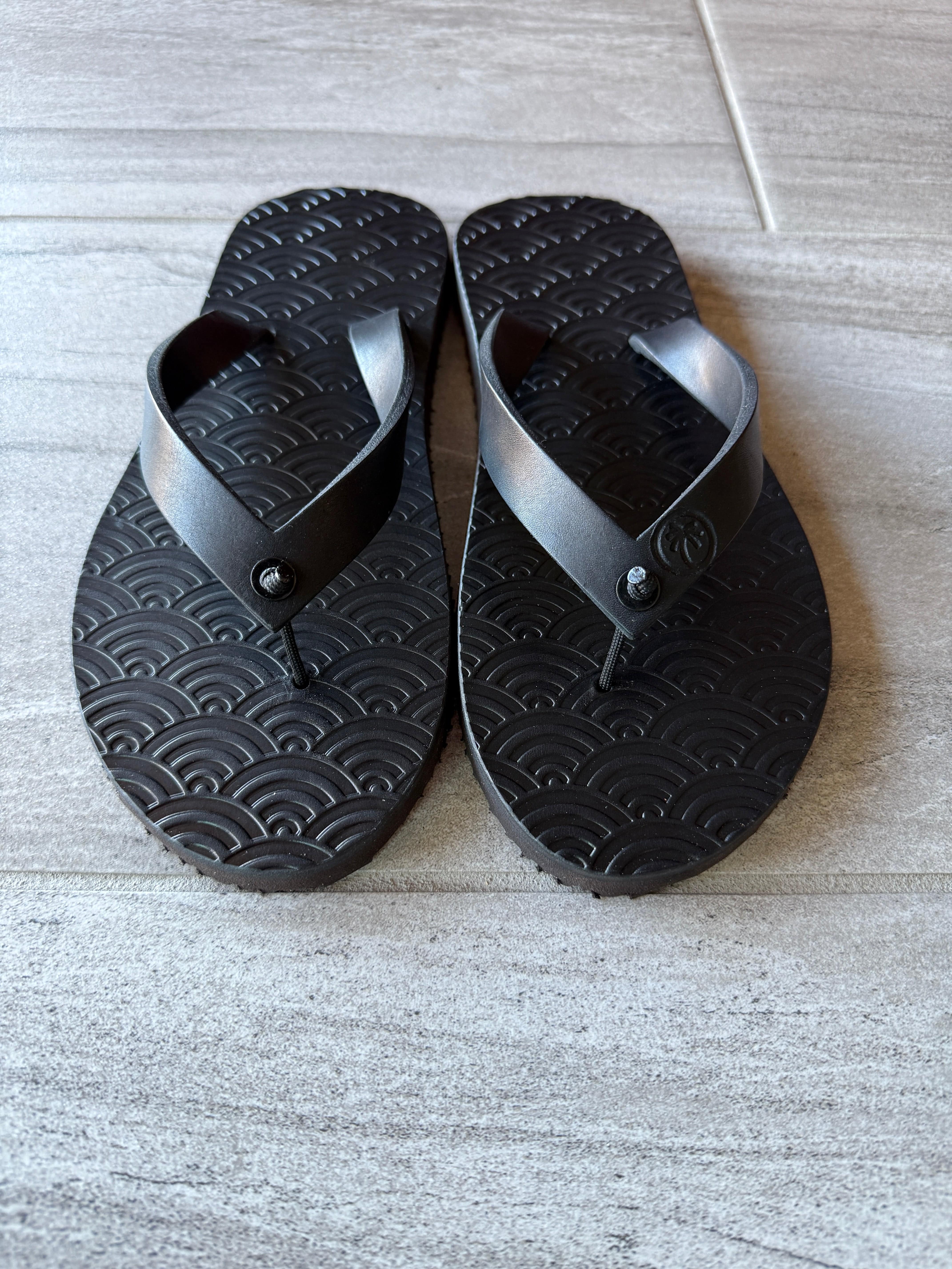 Toehold Samurai Armor black flip-flops with detailed strap design and sturdy sole, suitable for casual wear.
