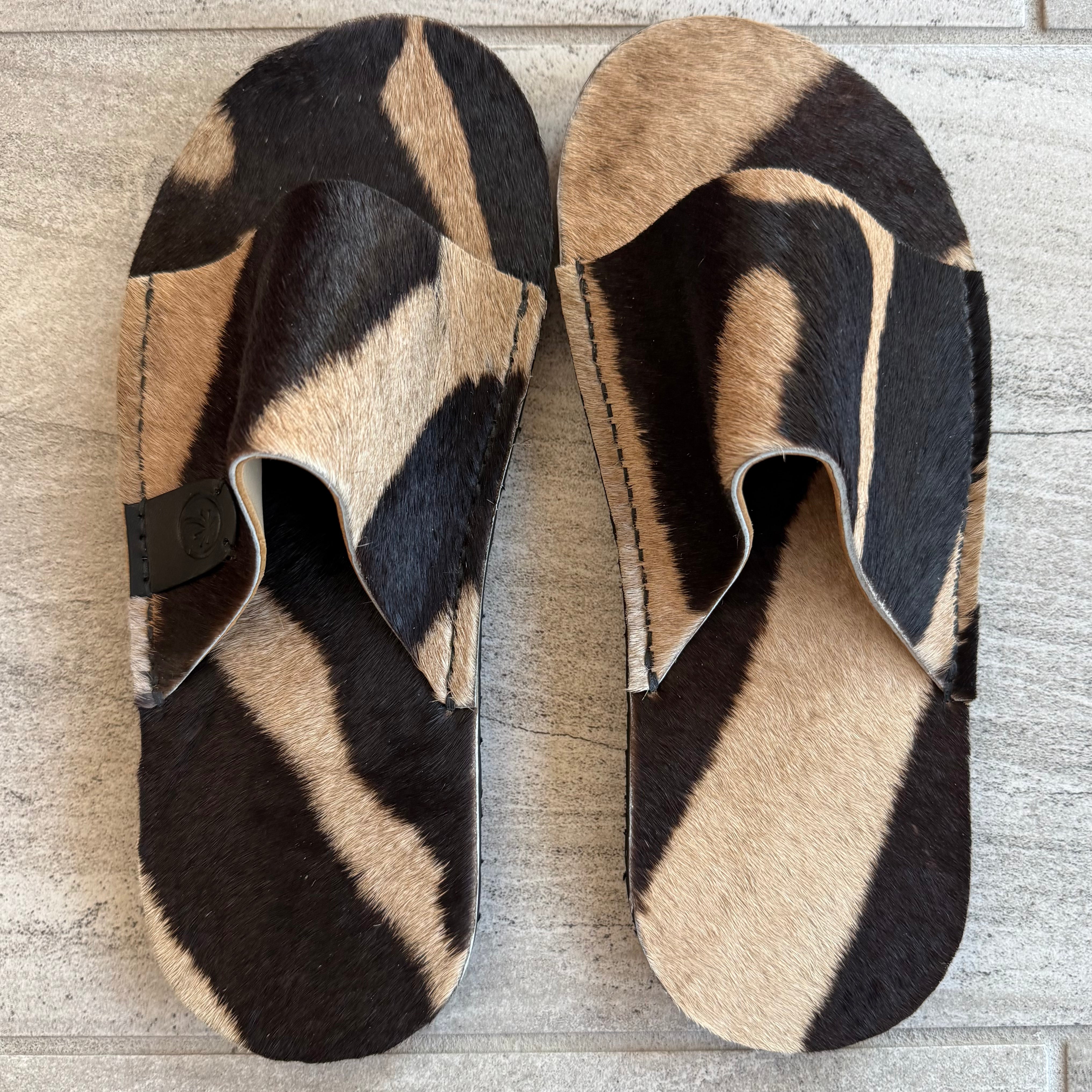 Toehold Zebra Slides featuring black and white striped design, open-toe sandals with cushioned footbed for casual summer wear.