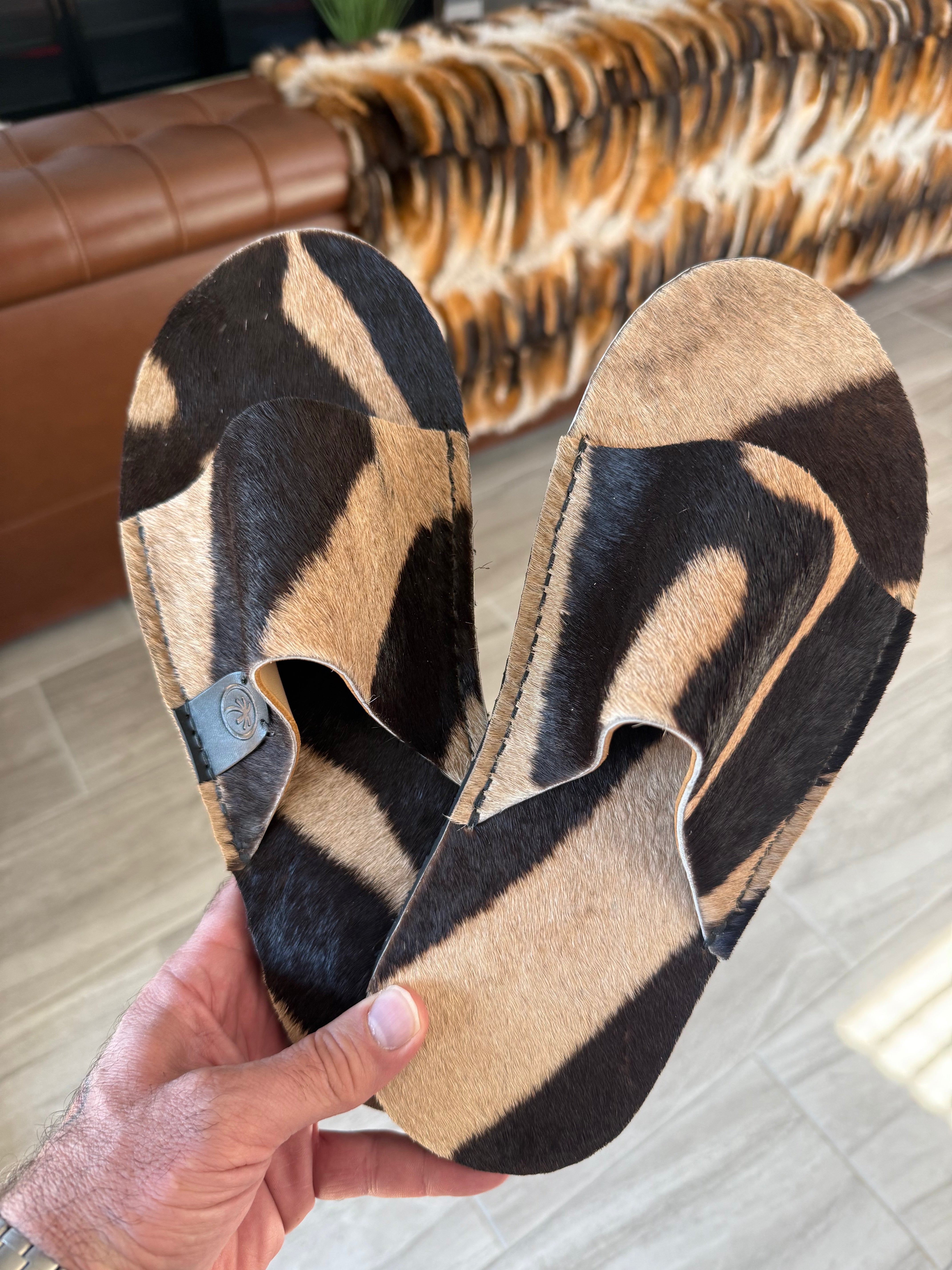 Toehold Zebra Slides featuring black and white striped design, open-toe casual footwear with cushioned sole.