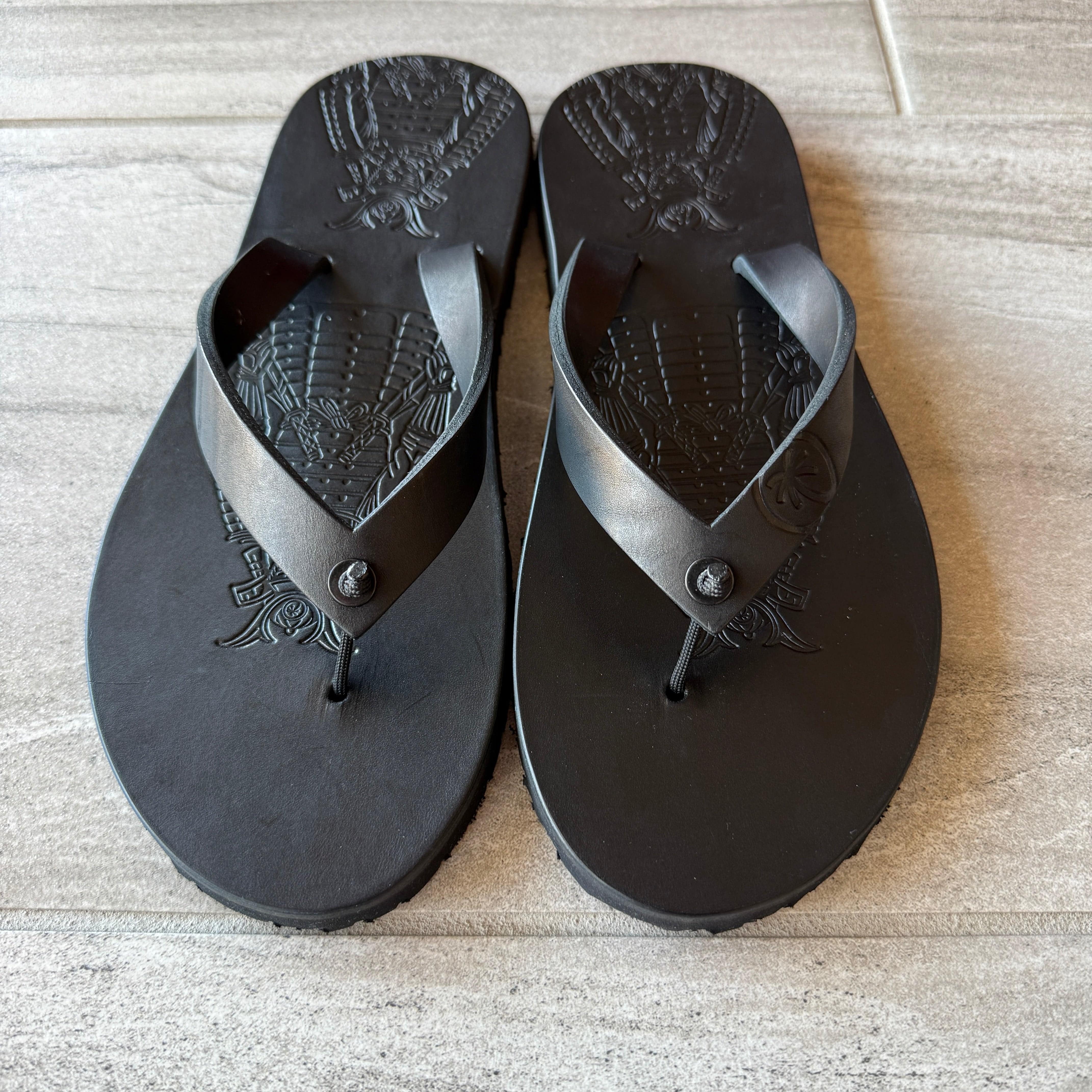 Toehold Samurai Black flip-flops with black straps and textured soles, casual footwear for warm weather.