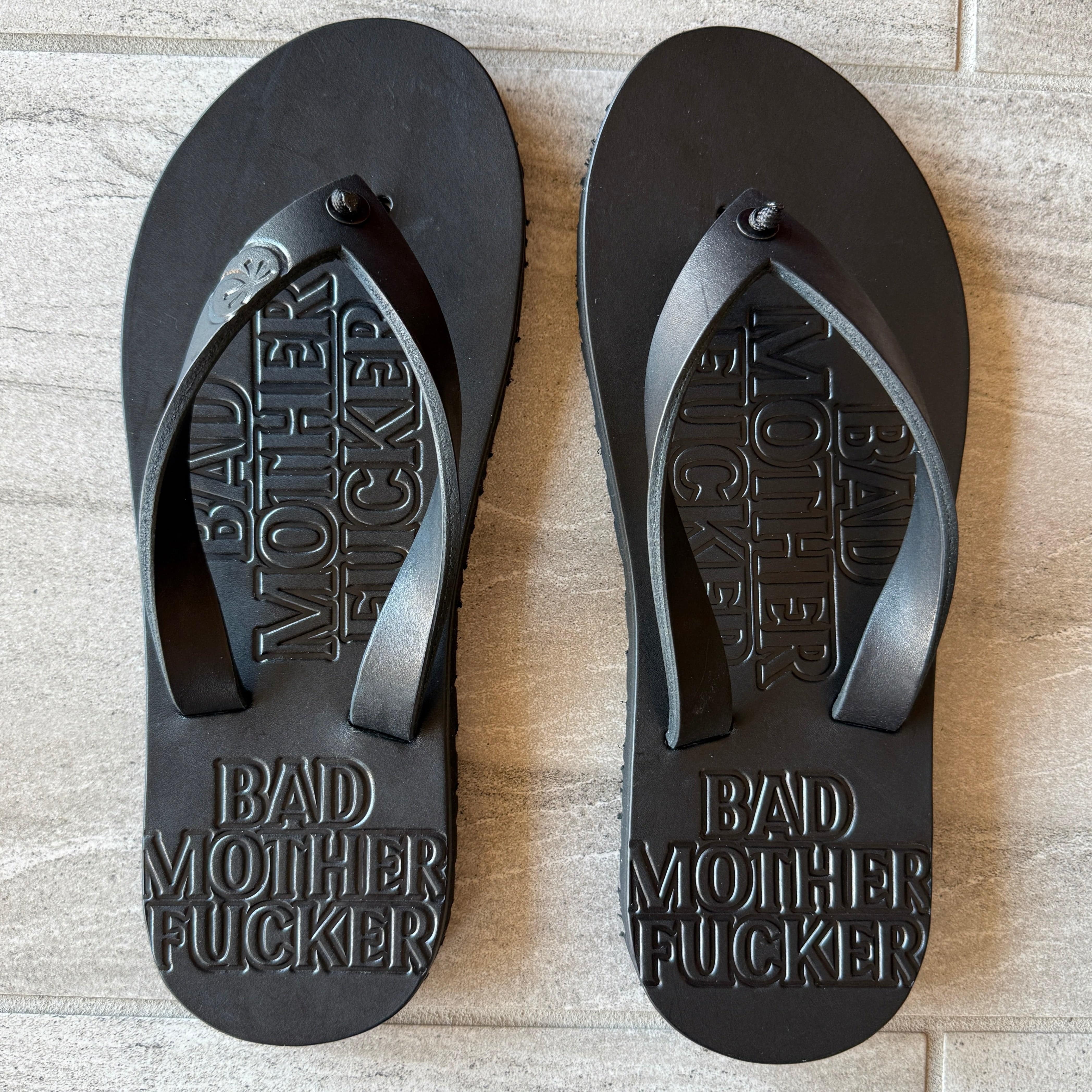 Toehold BMF black flip-flops with cushioned straps and textured soles, displayed on a neutral background.