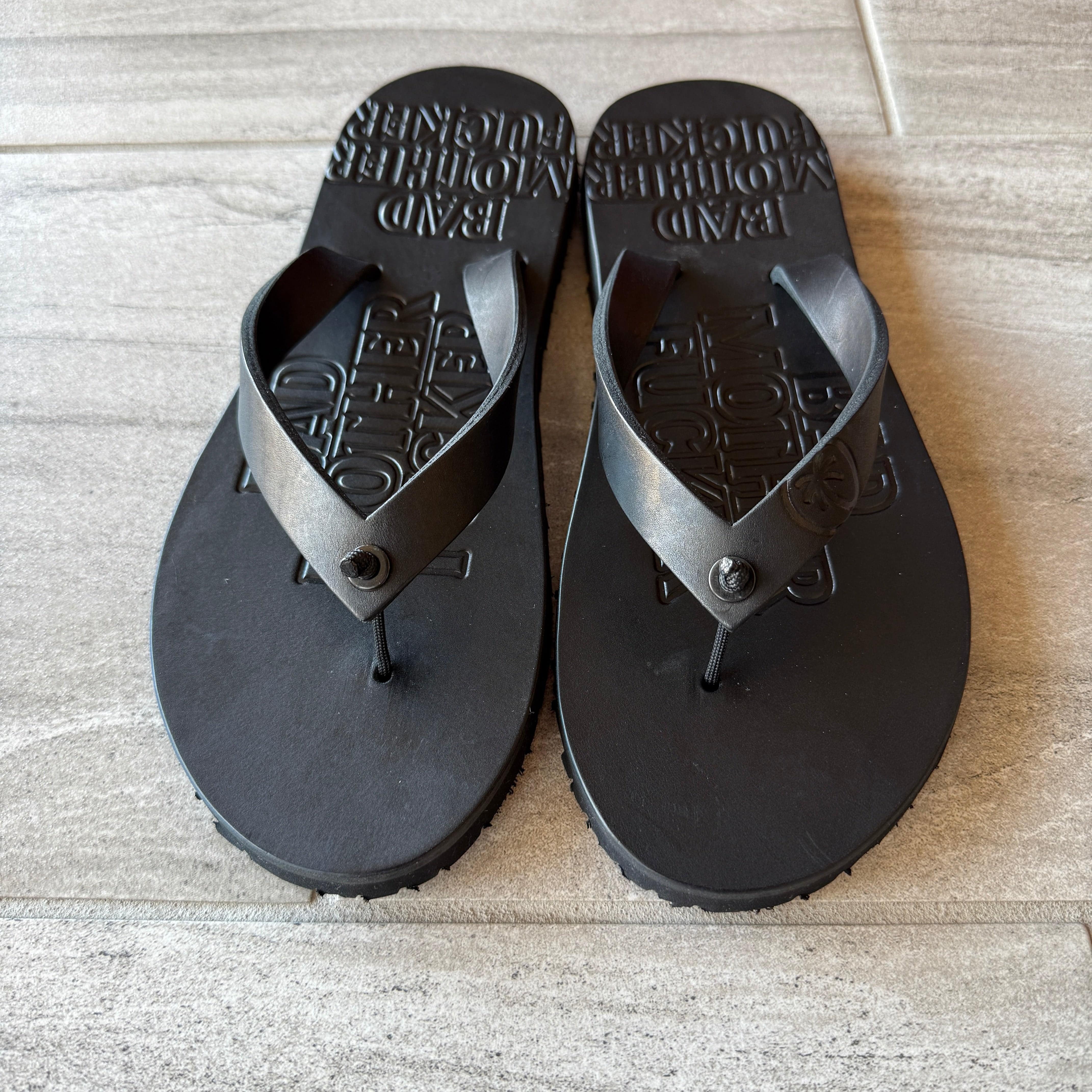 Toehold BMF black flip-flops with cushioned straps and textured soles, displayed on a neutral background.