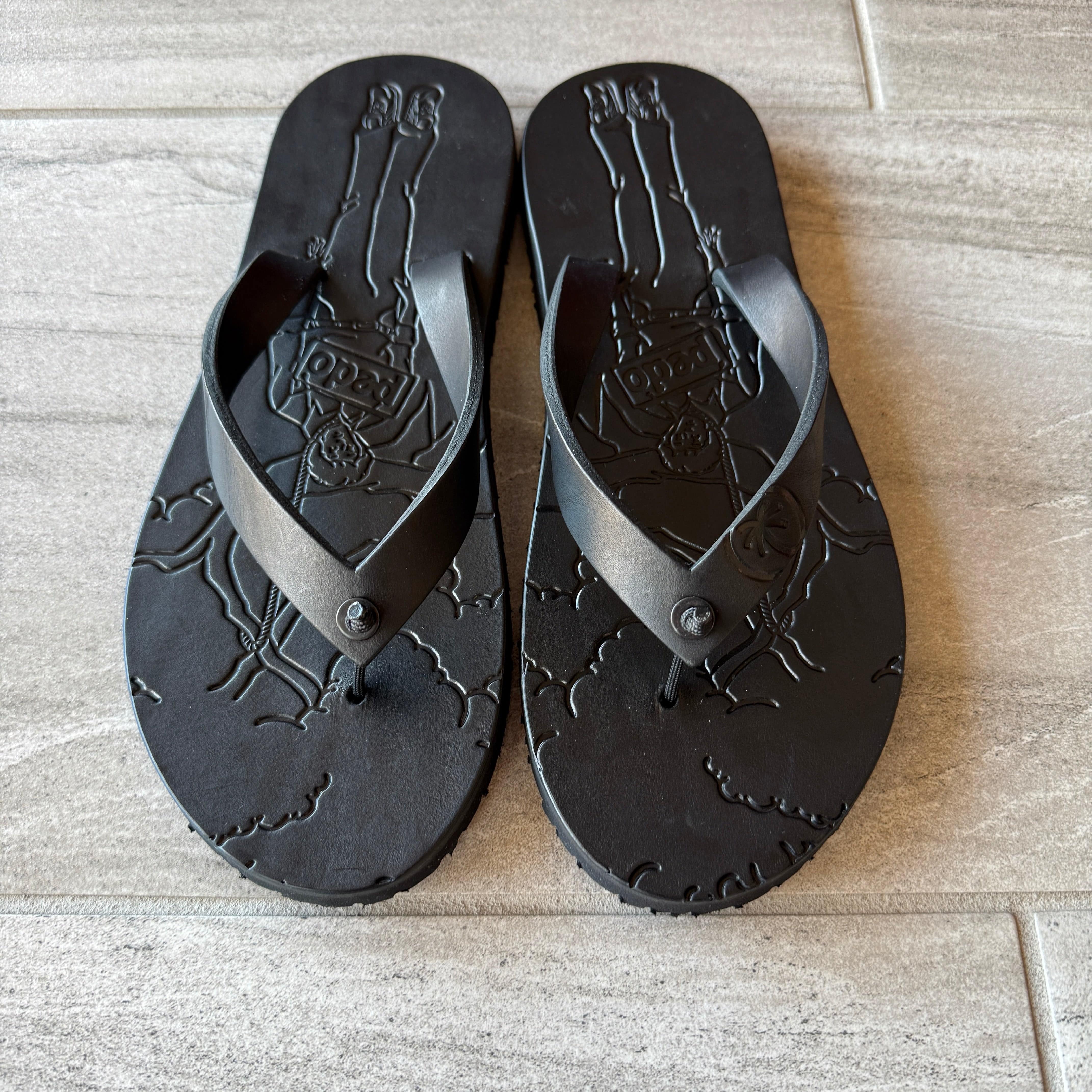 Black Pedo Hunter flip-flops by Toehold with cushioned straps and textured soles, displayed on a plain background.