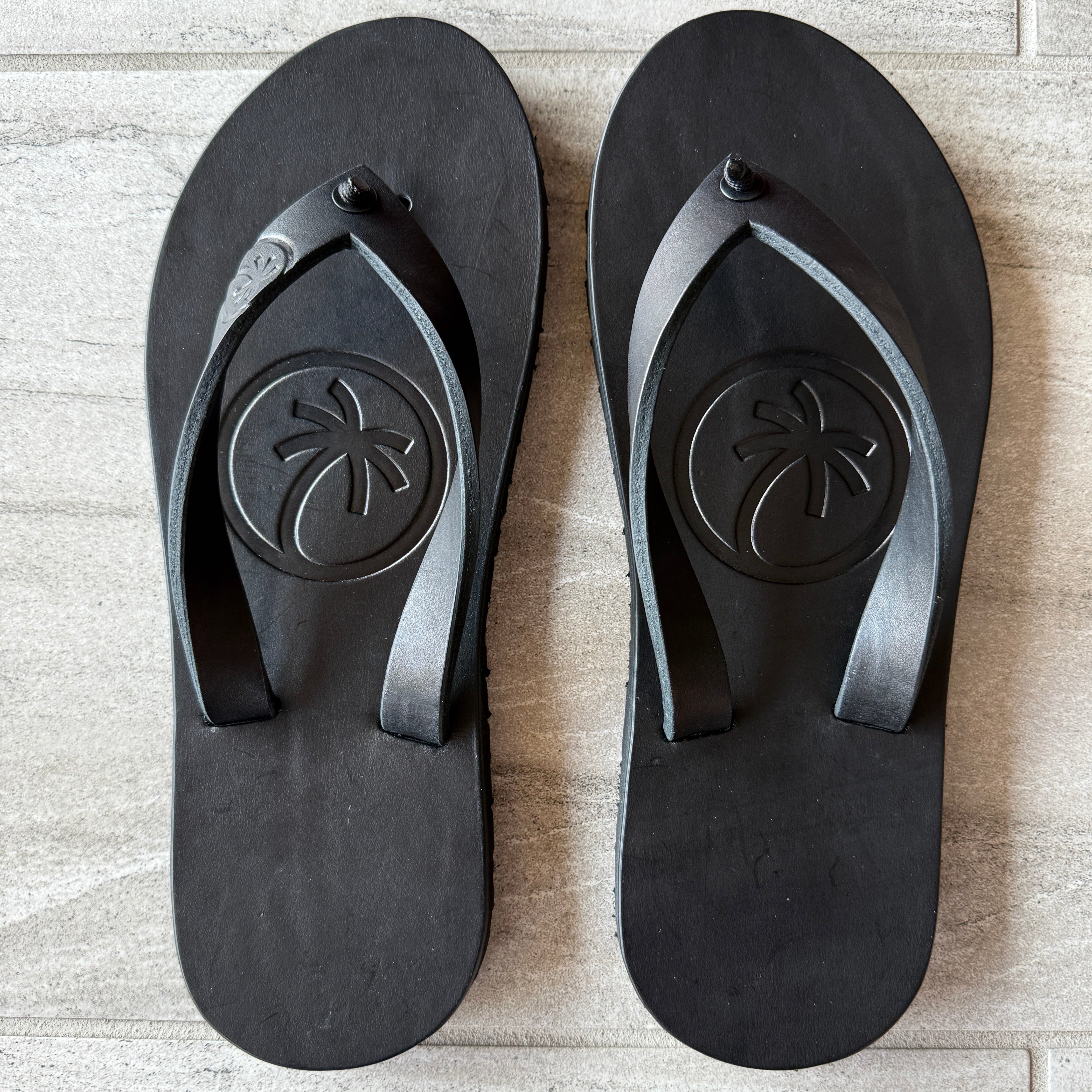 Toehold "Classic" black flip-flops with cushioned straps and textured soles, displayed on a neutral background.