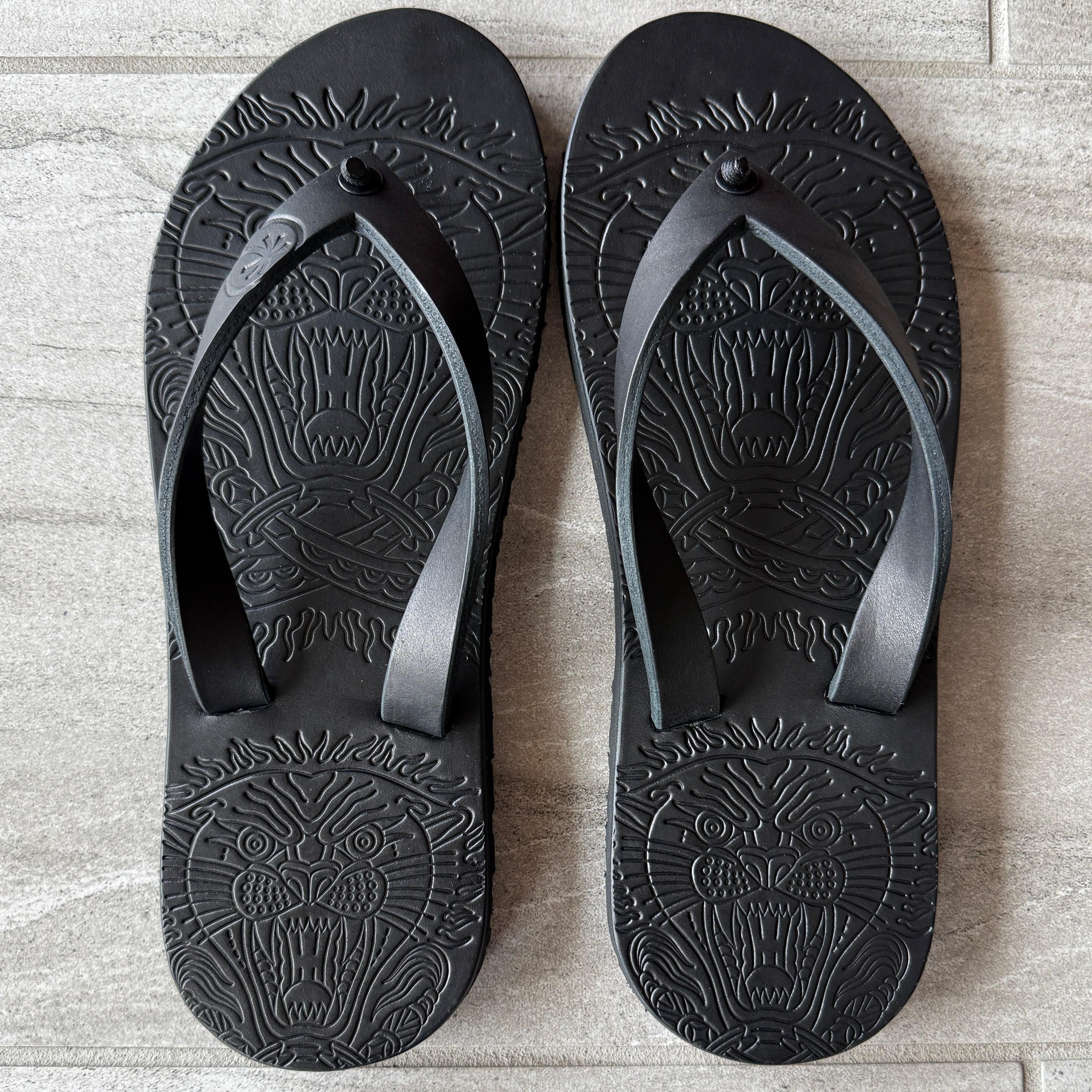 Black Toehold Panther flip-flops with cushioned straps and textured soles, designed for comfort and casual wear.