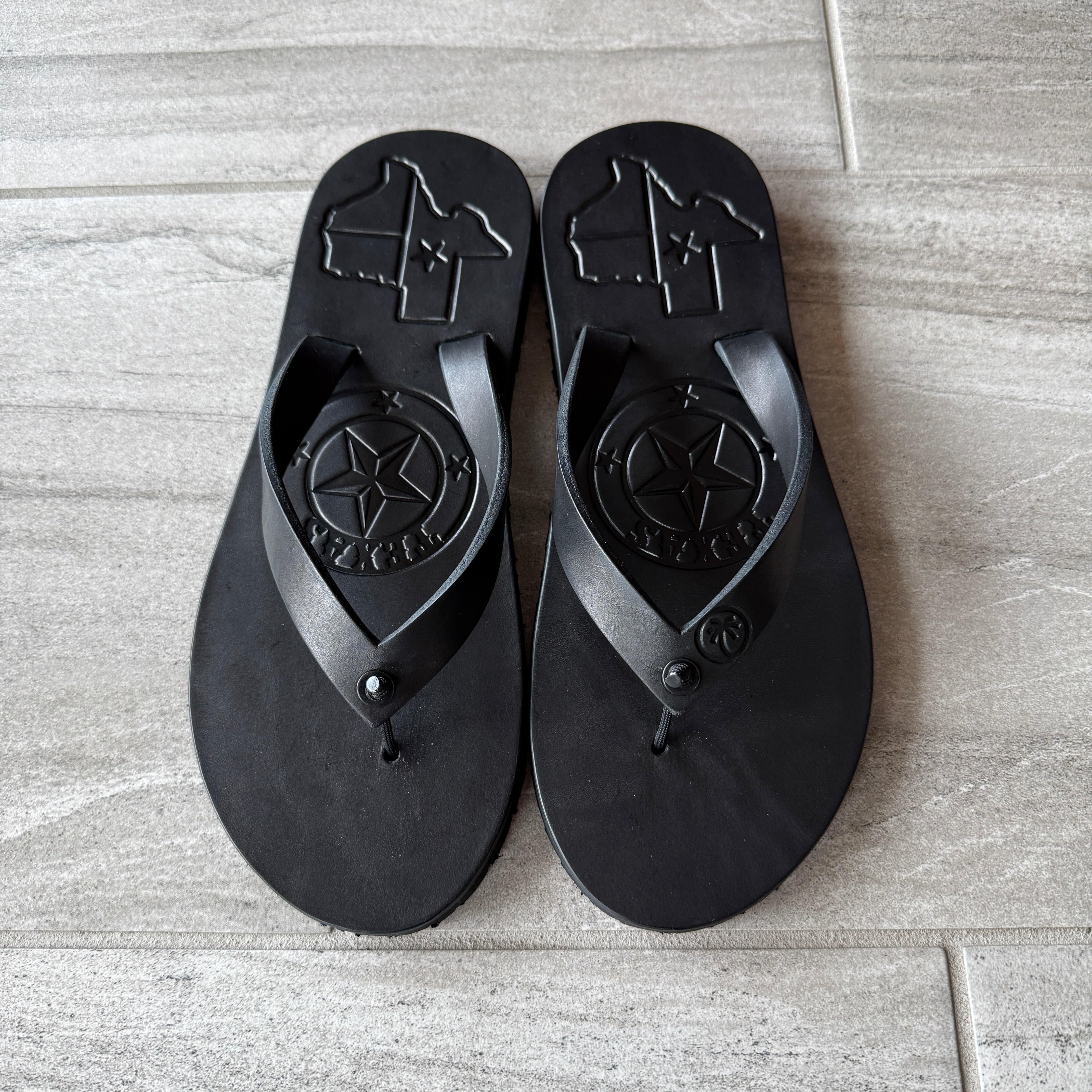 Toehold Texas Black flip-flops with black straps and cushioned soles, casual footwear for warm weather.