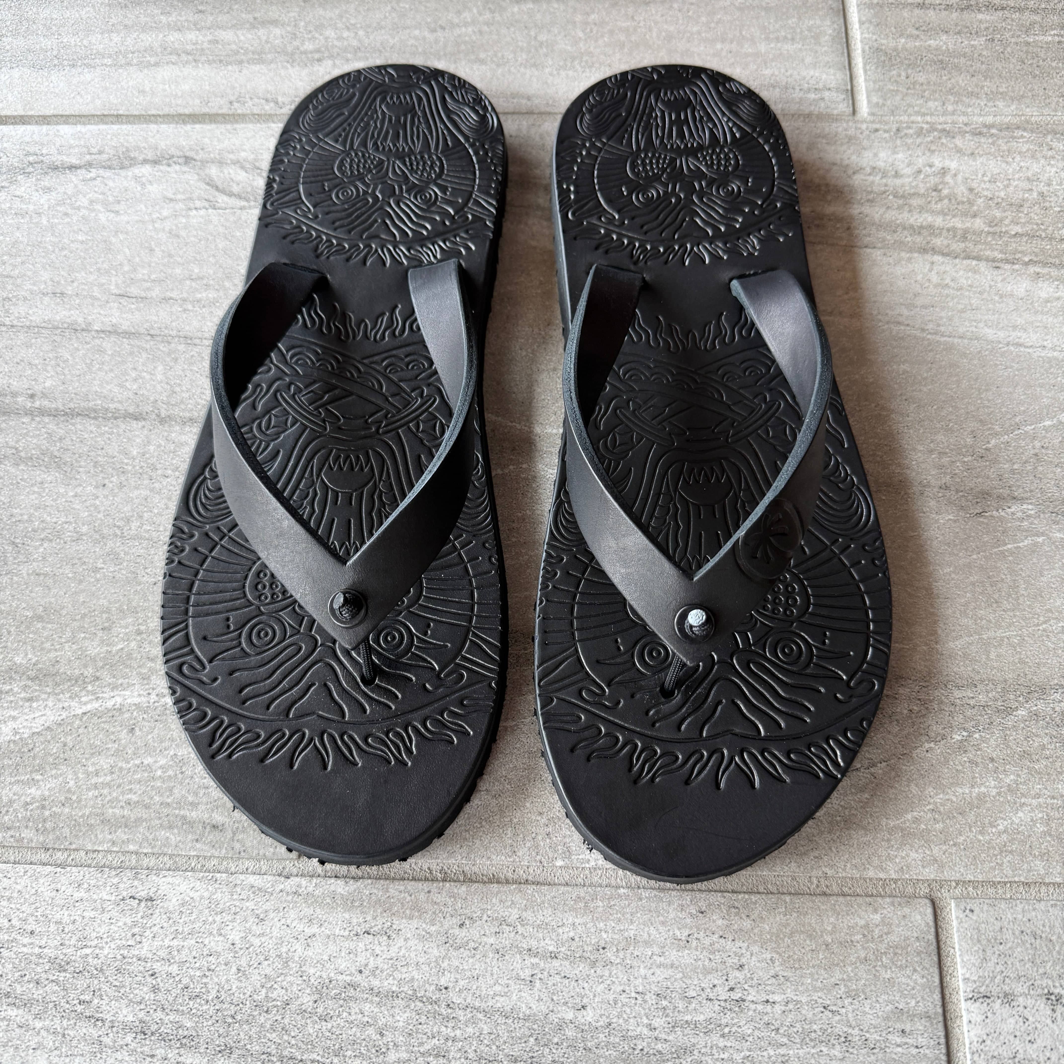 Black "Panther" flip-flops by Toehold featuring a sleek design and comfortable straps, shown on a plain background.
