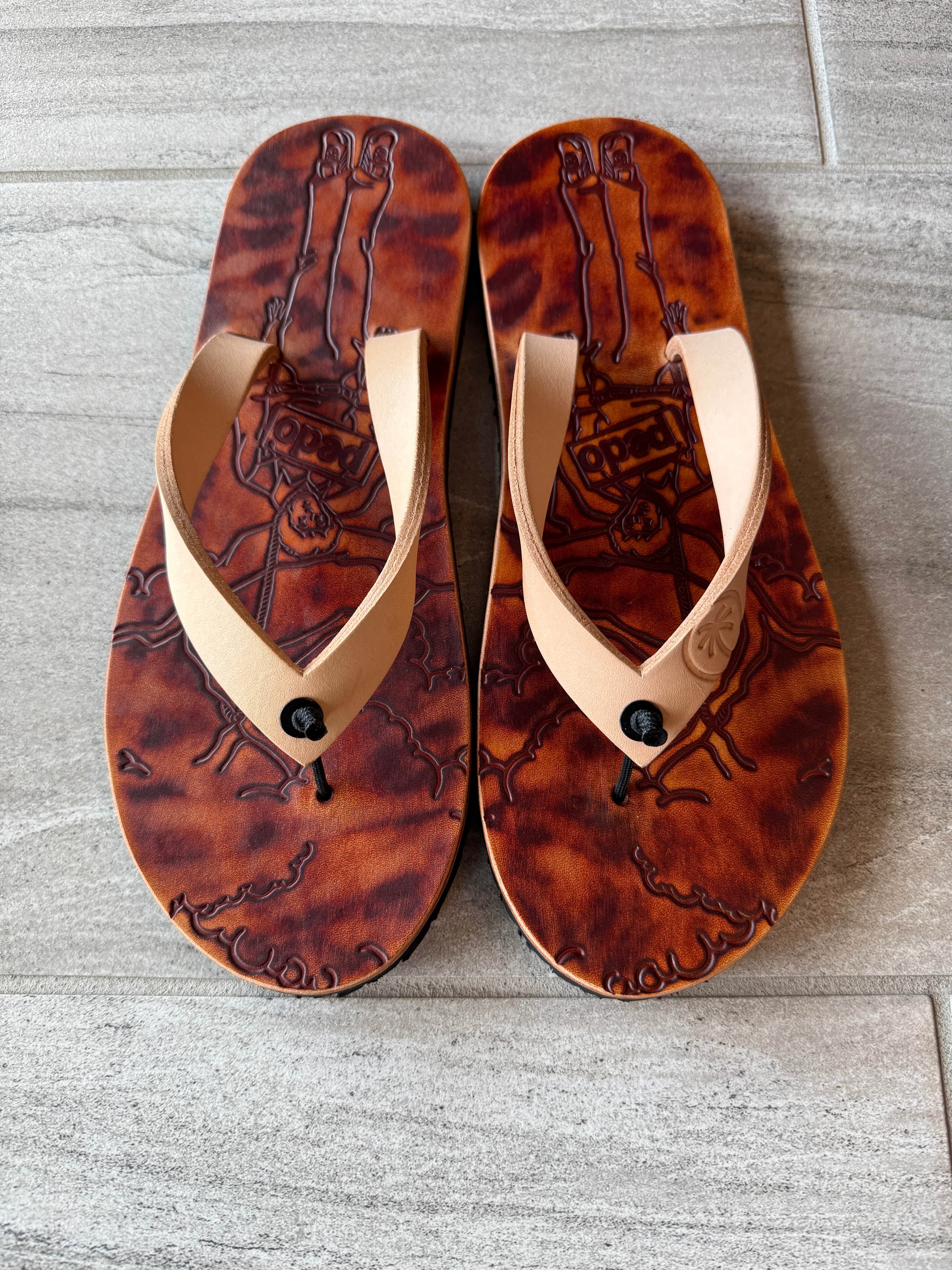 Toehold Pedo Hunter flip-flops with black straps and textured soles, displayed on a white background.