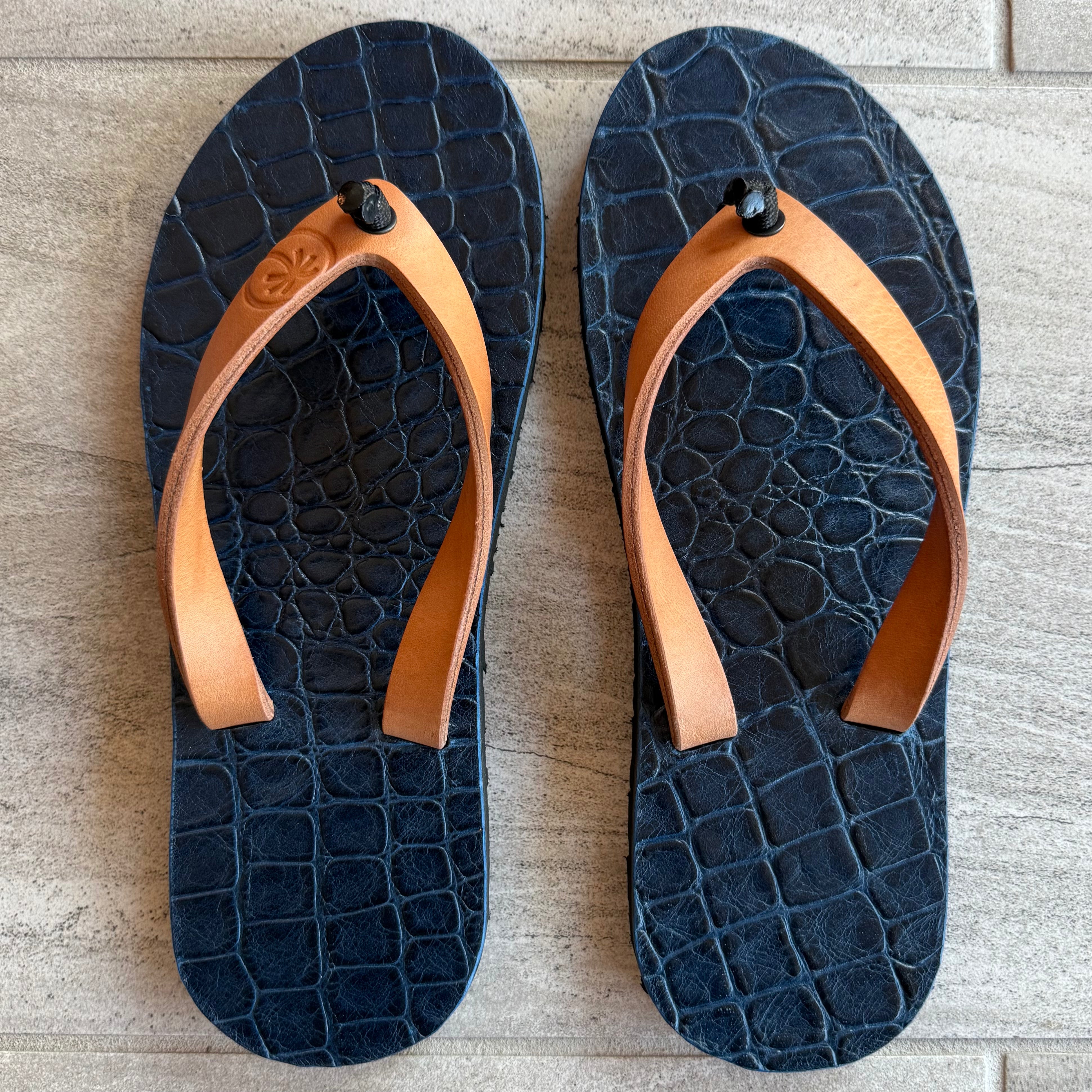 Saltwater Crocodile ToeHold flip-flops featuring crocodile print design and comfortable rubber straps.