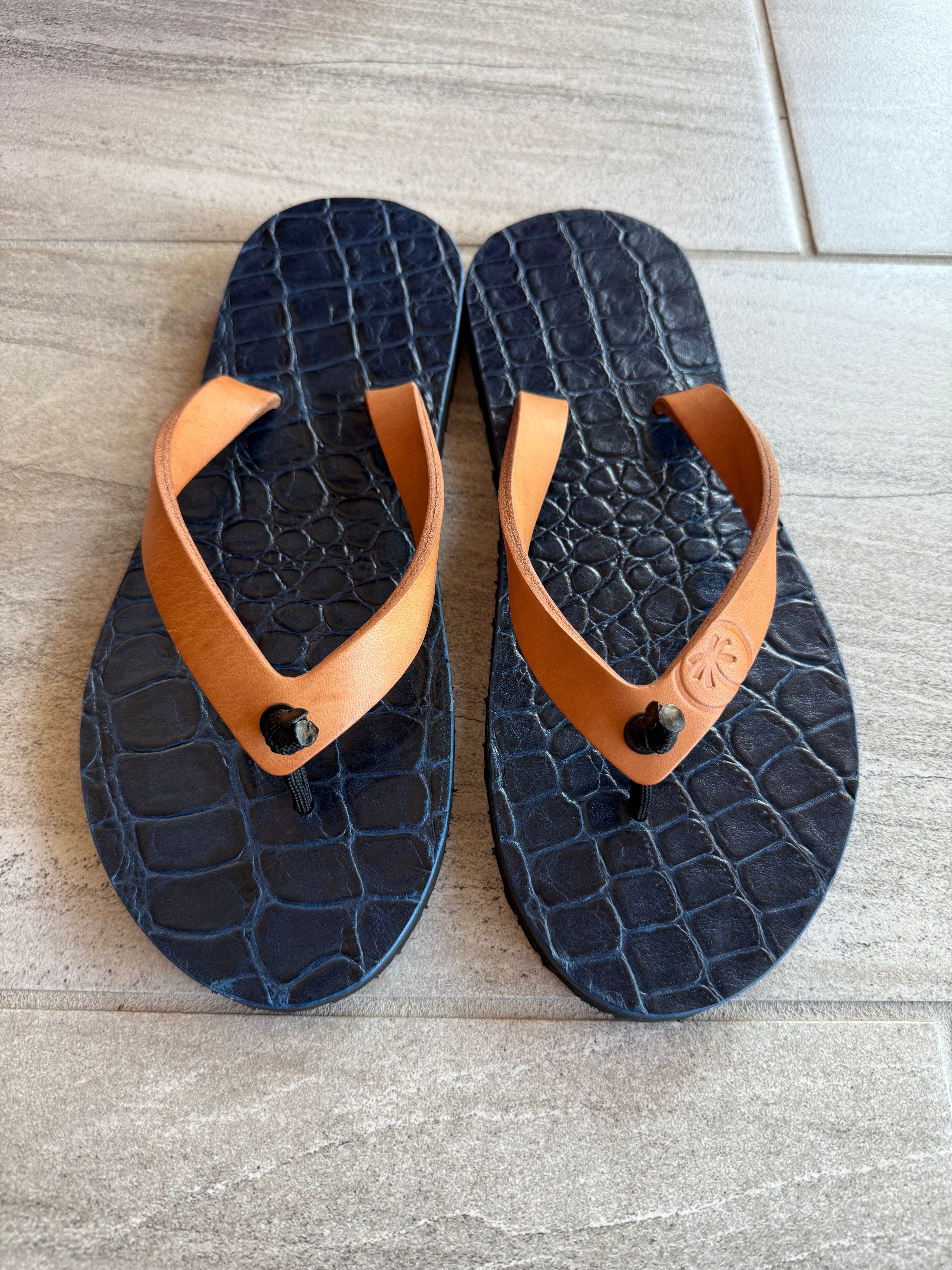 Saltwater Crocodile ToeHold flip-flops with crocodile print and black straps, showcasing the detailed design and comfortable sole.