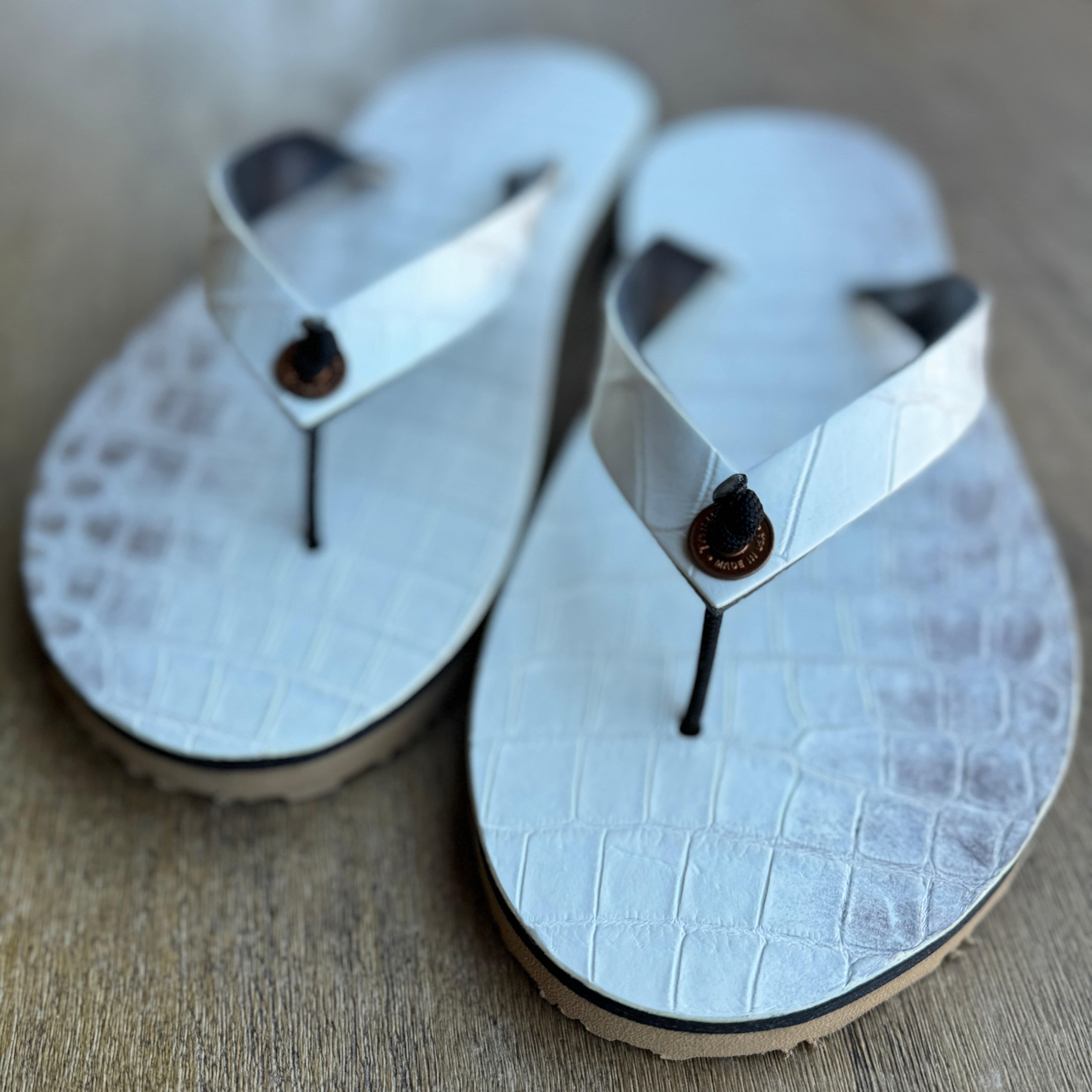 Toehold Himalayan Crocodile flip-flops featuring a crocodile design on black footwear for casual wear.