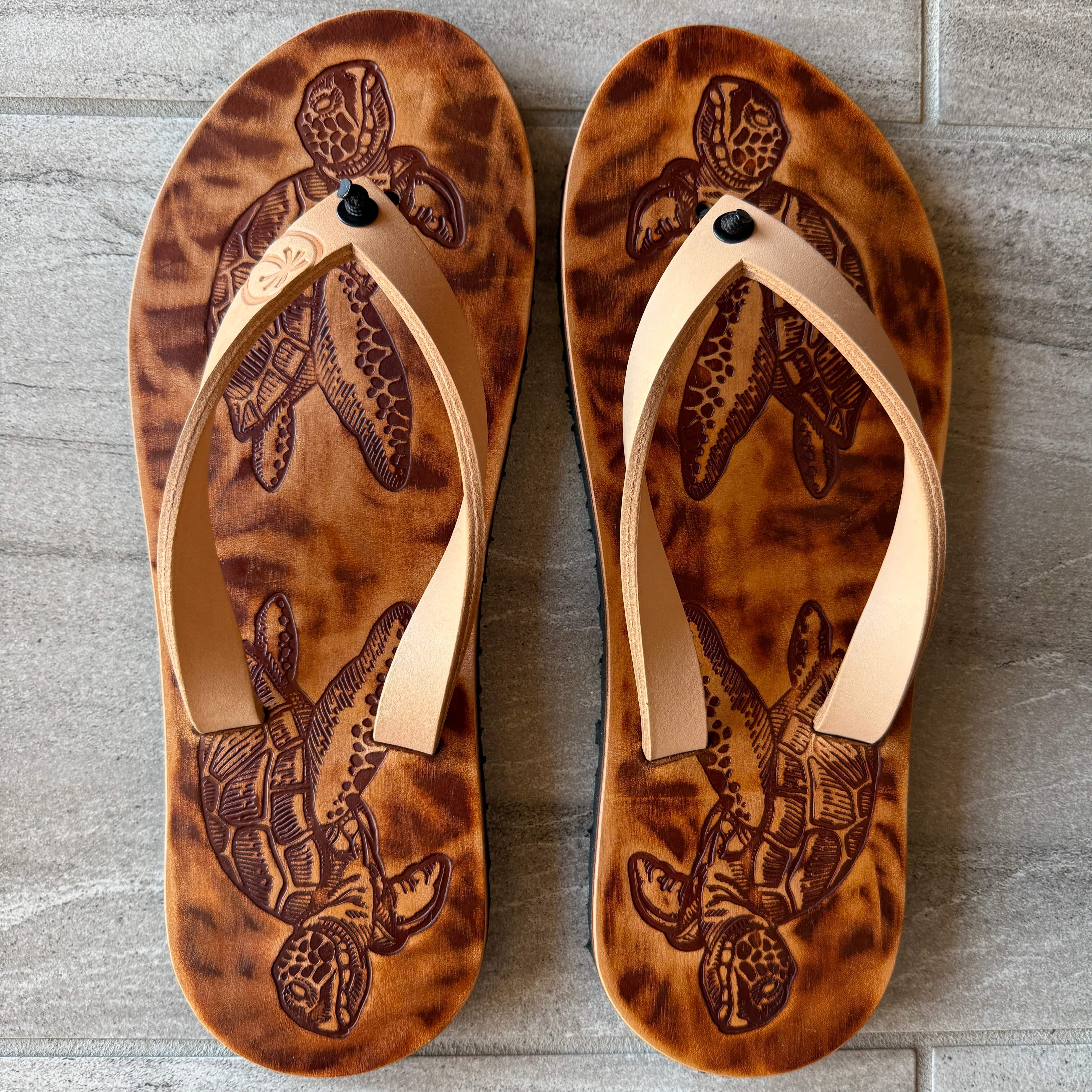 Toehold sea turtle flip-flops featuring a colorful sea turtle design on the straps and sole, perfect for casual summer wear.