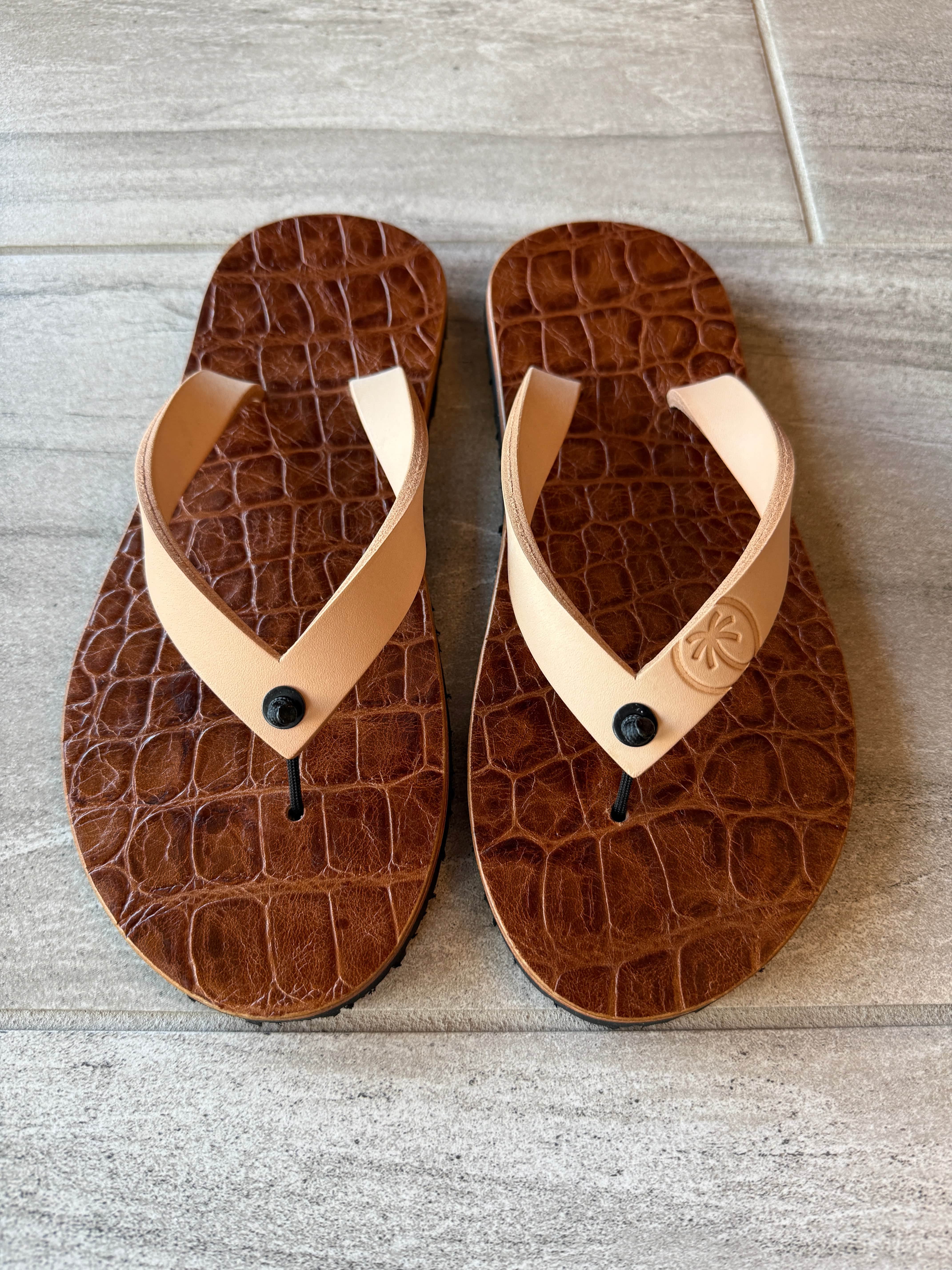 ToeHold Nile Crocodile flip-flops featuring crocodile-patterned straps and comfortable rubber soles.
