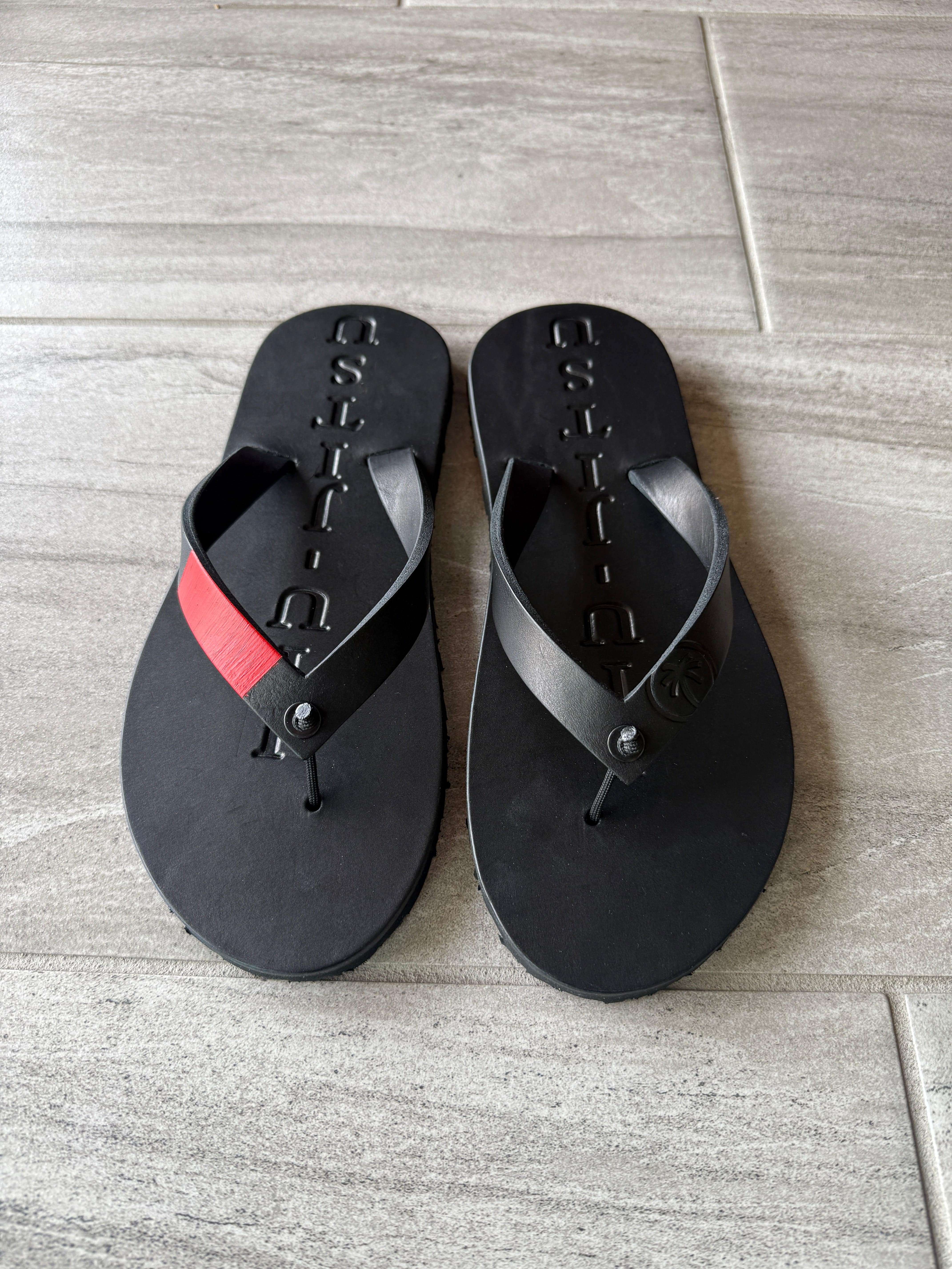 Toehold Blackbelt flip-flops with black straps and textured sole, casual footwear lined up on a white background.