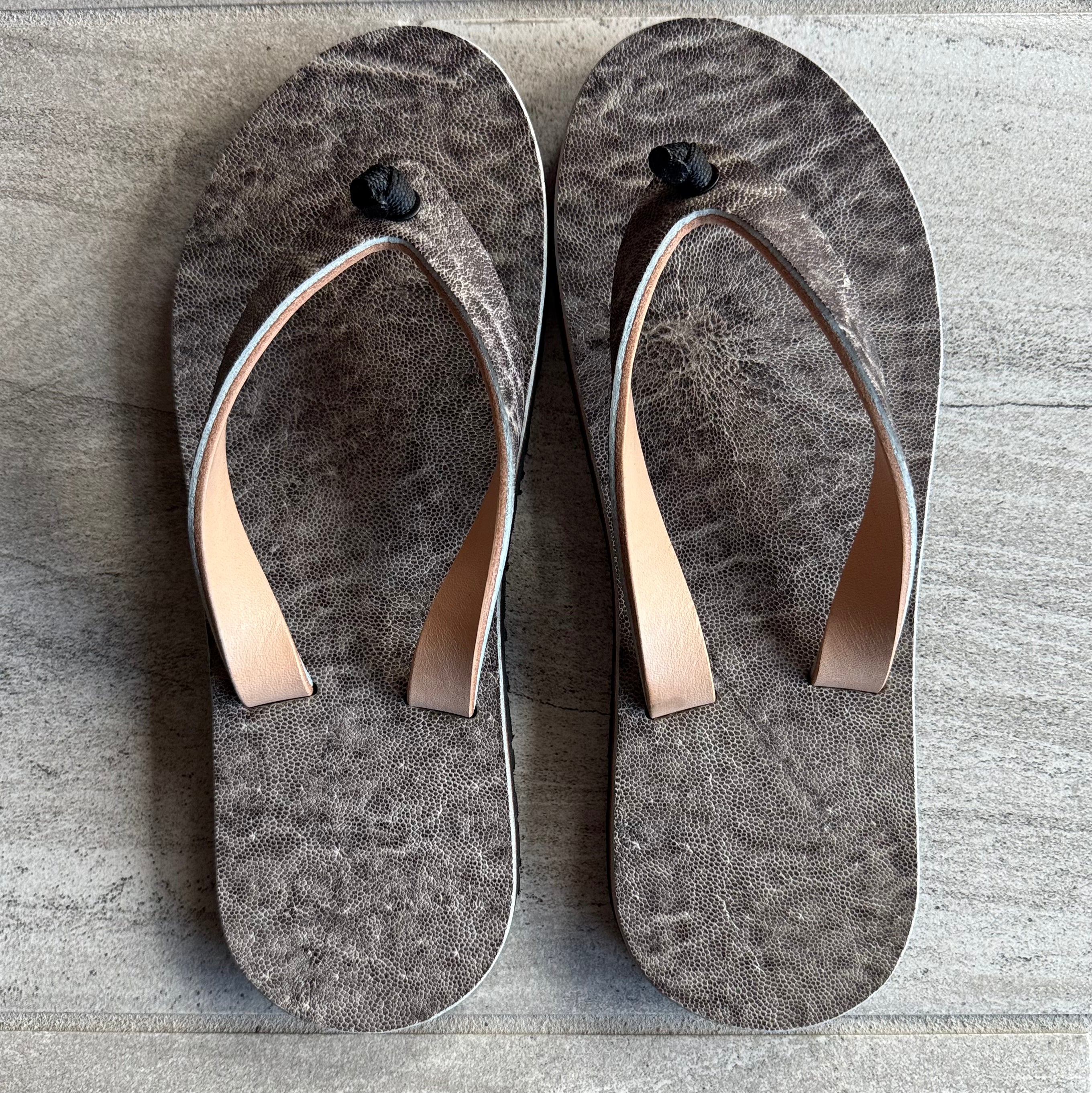 Toehold Ghost Elephant flip-flops featuring a playful ghost elephant design on black rubber soles.