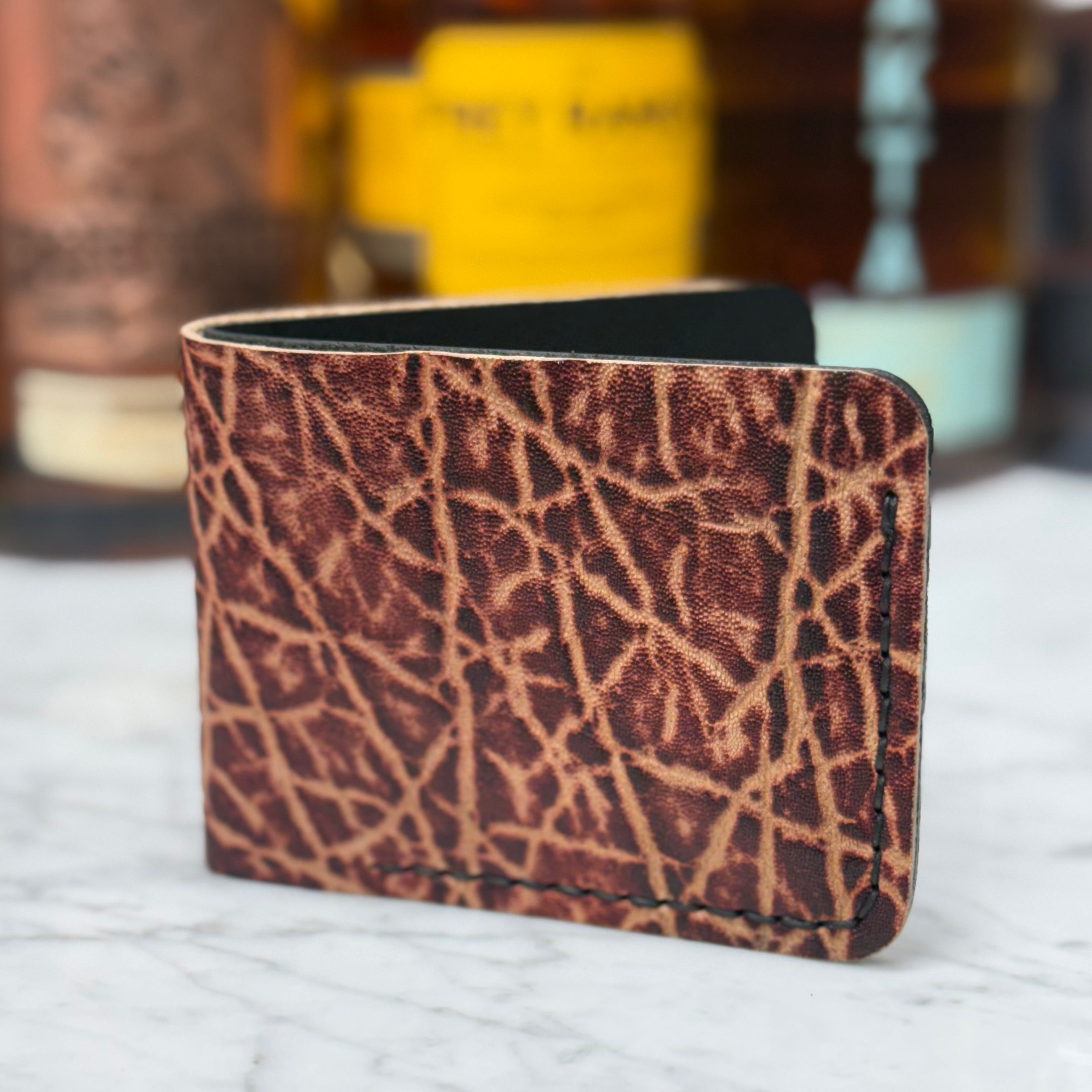 Toehold man killing elephant bi-fold wallet with detailed leather craftsmanship and multiple card slots, shown open in the image.