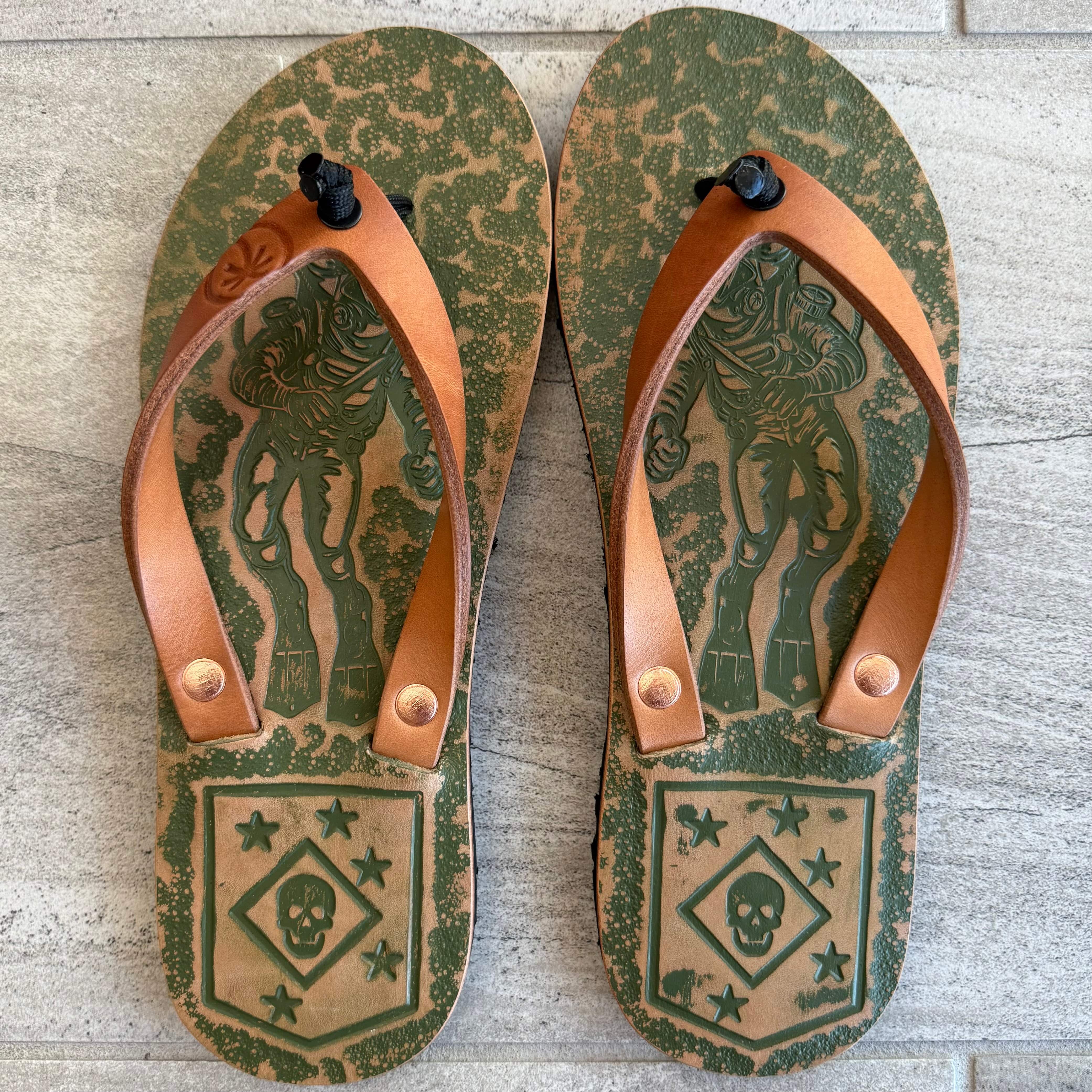 Toehold Marine Raiders flip-flops with navy straps and rubber soles, featuring marine-inspired design details.