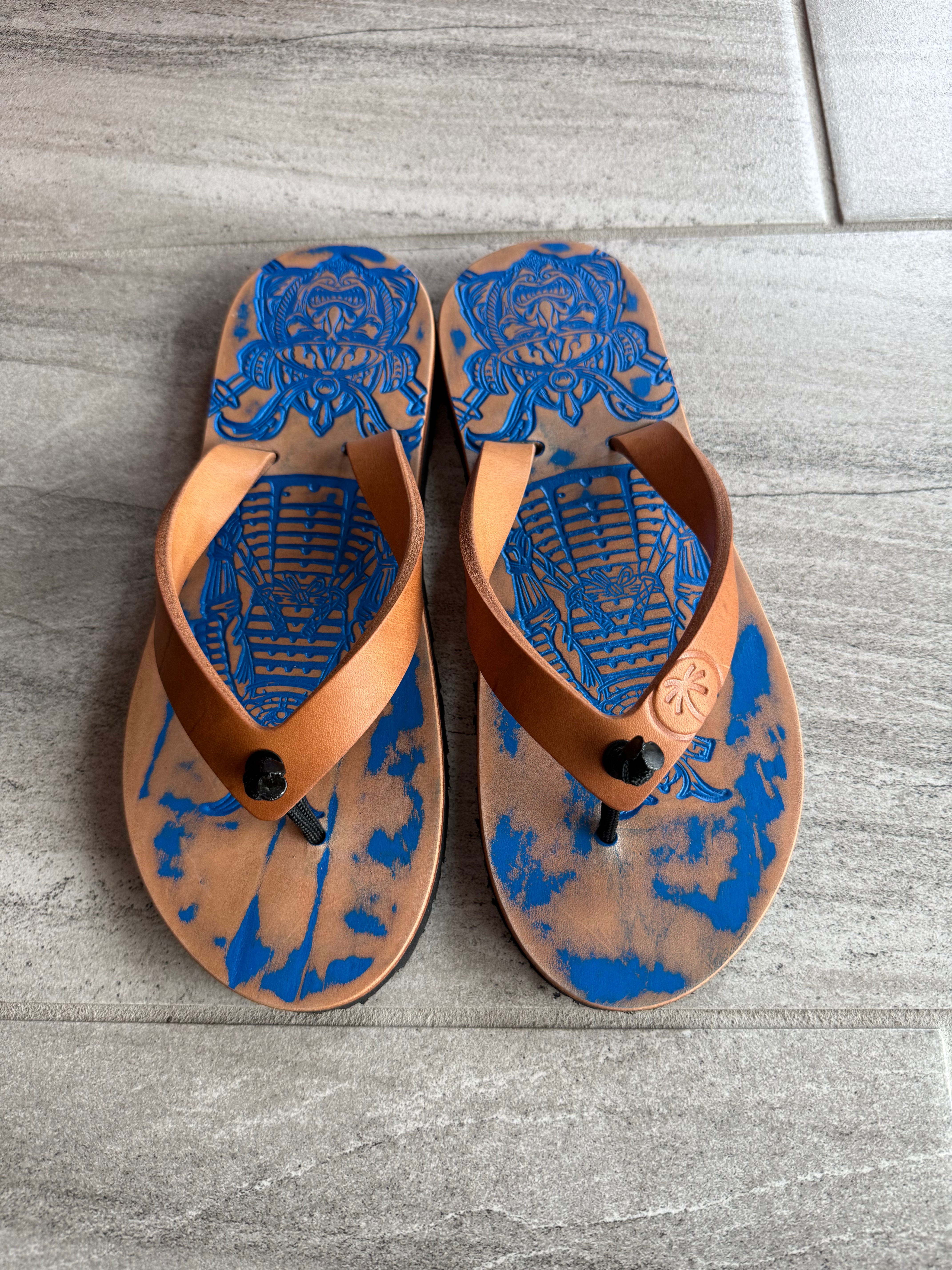 Toehold Royal Samurai flip-flops with black straps and decorative gold accents, shown on a neutral background.
