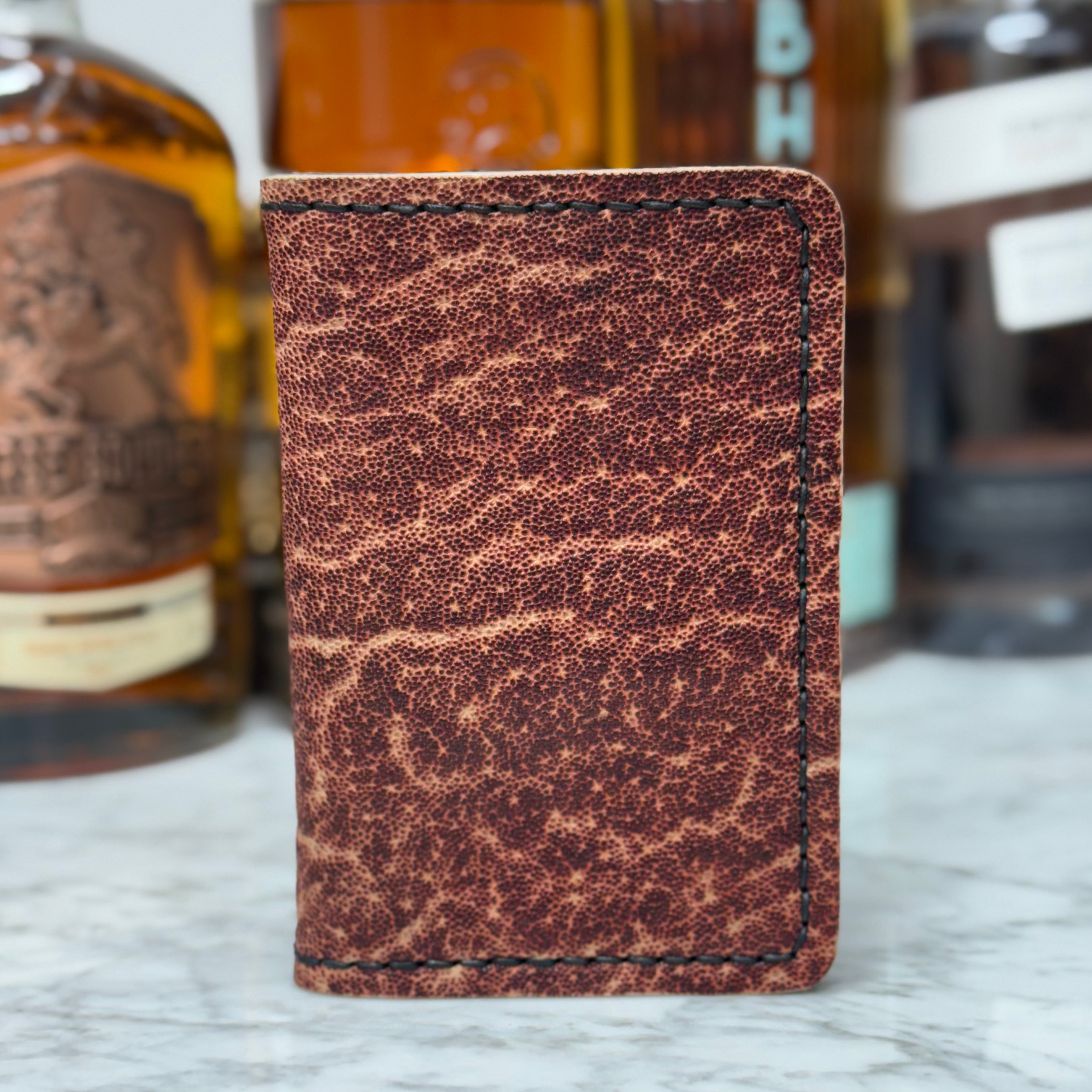 Toehold Man Killing Elephant passport wallet with leather exterior and multiple card slots, featuring an illustrated elephant design.