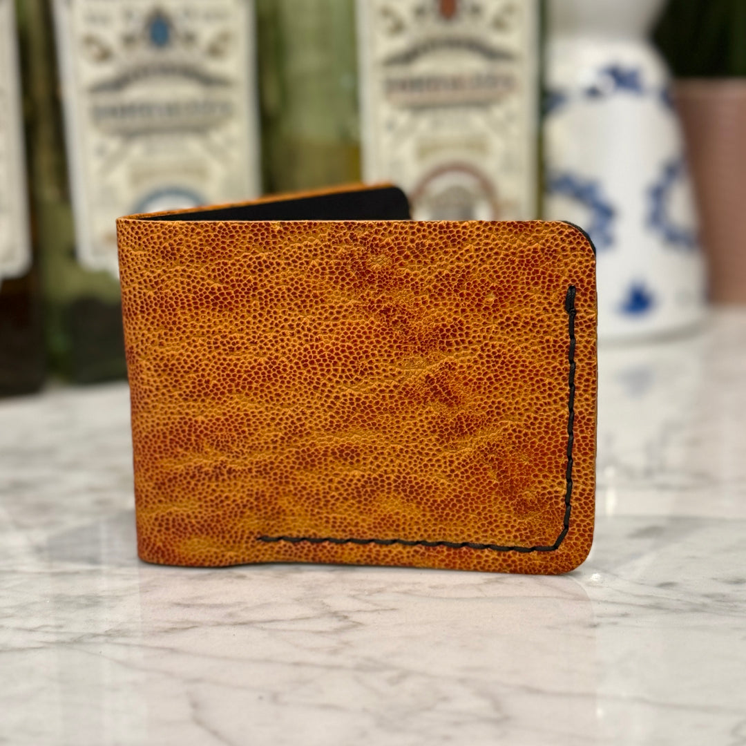 Golden Elephant Toehold bi-fold wallet with textured leather finish, featuring multiple card slots and a sleek compact design.