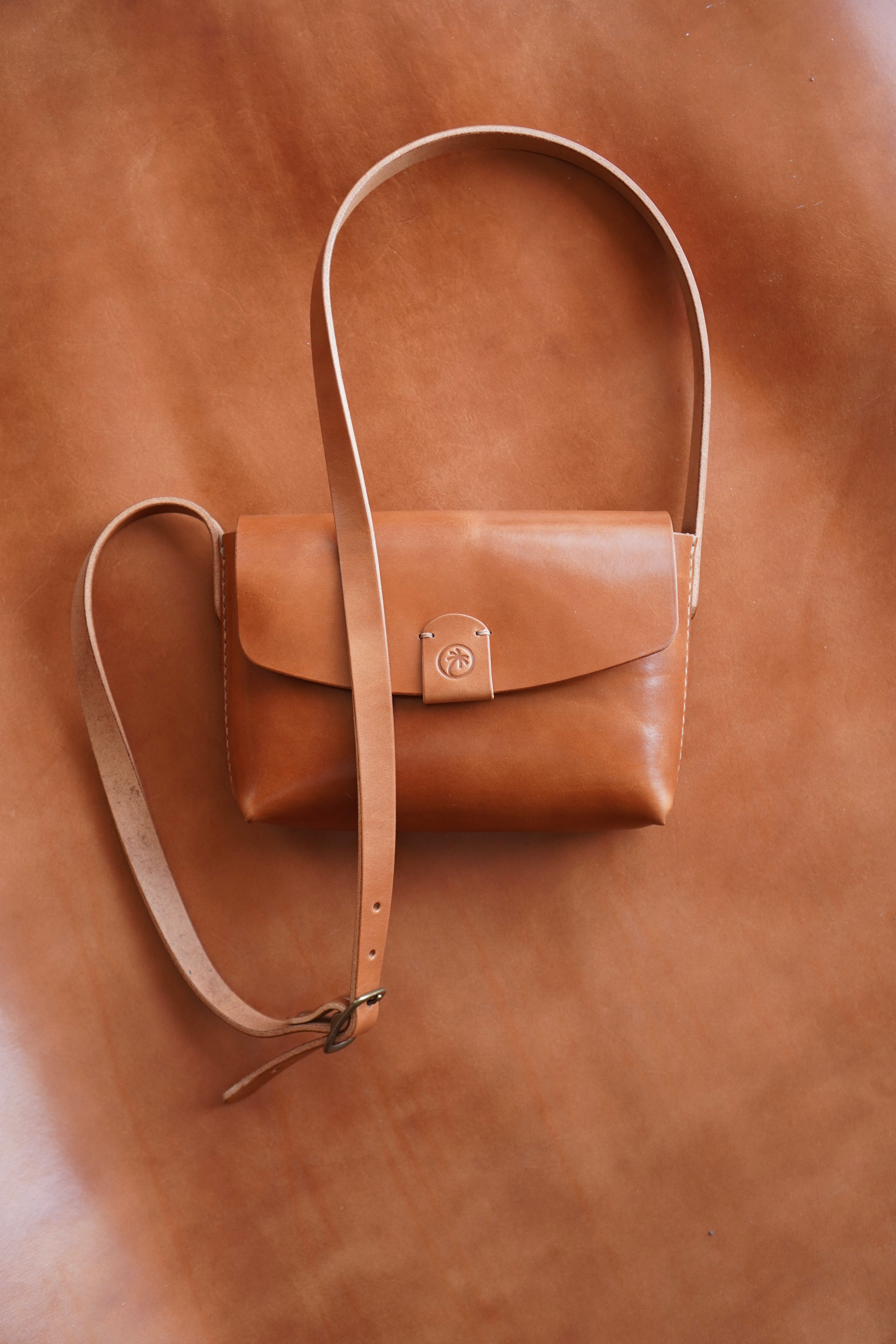 Toehold® Bag with sleek black leather finish, compact design, and silver hardware, perfect for everyday use.