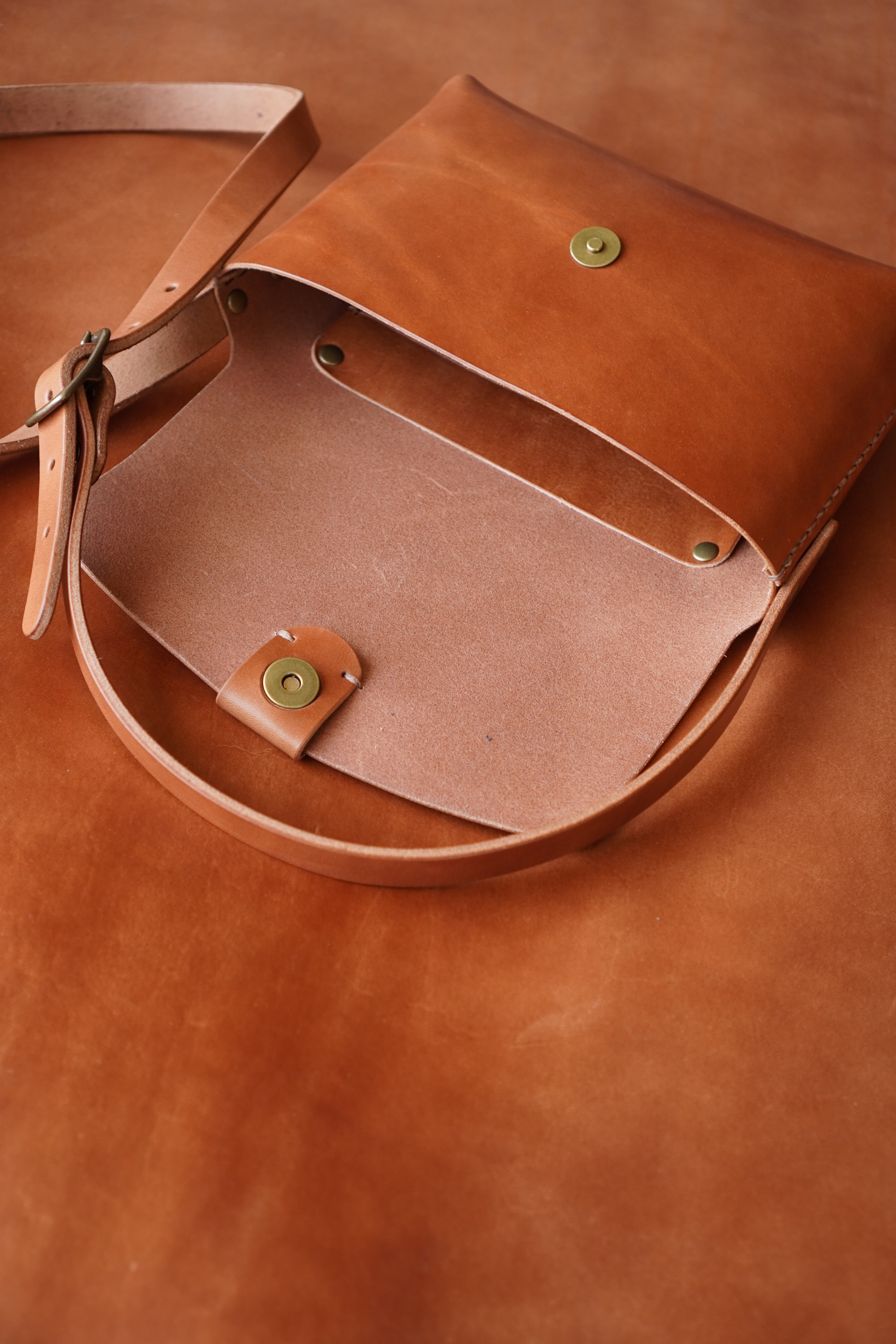 Toehold® Bag in black with top handle and zipper closure, featuring a sleek, modern design and compact size.