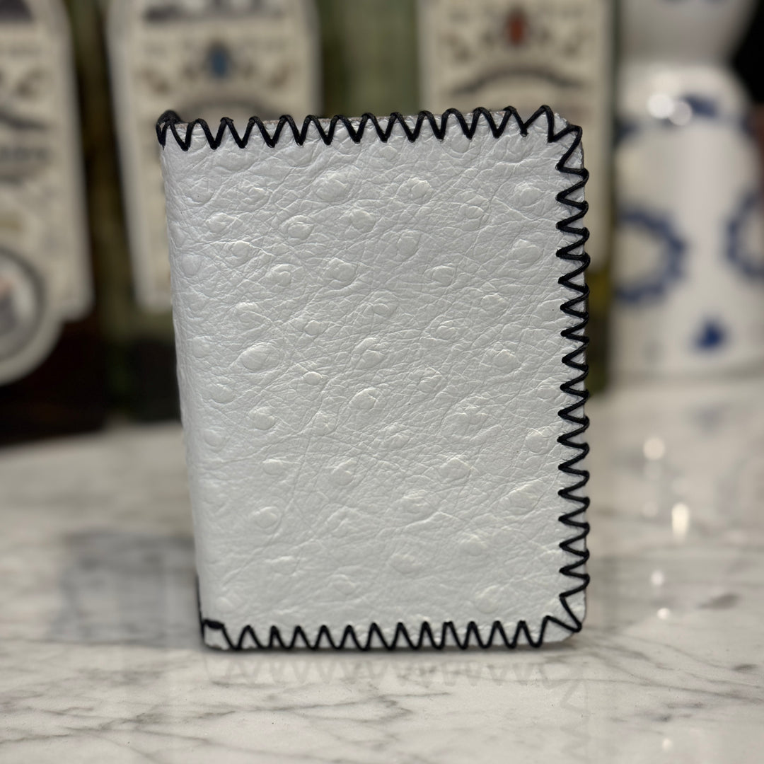 White pressed ostrich leather JW wallet by Toehold with multiple card slots and a sleek, textured finish.