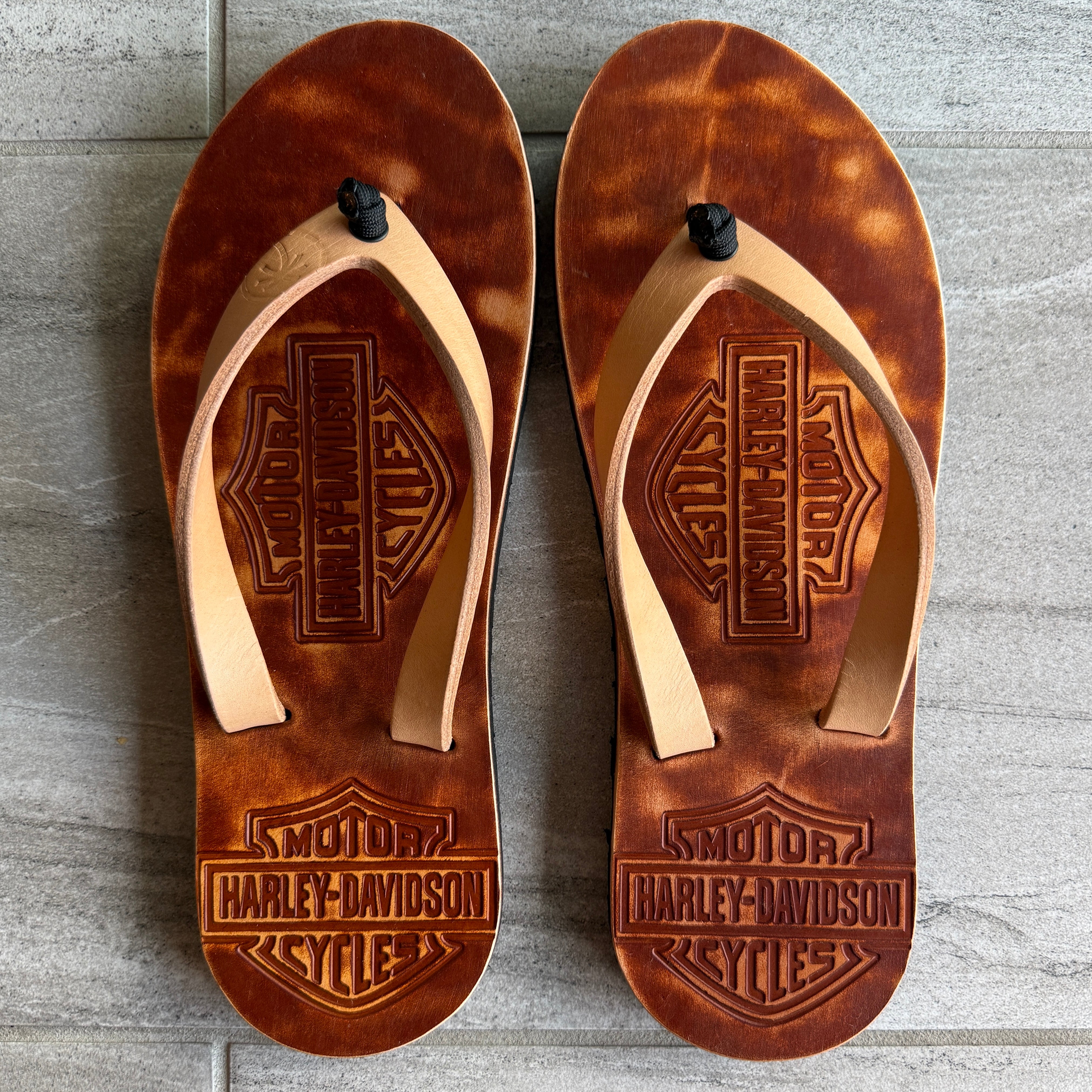 Women’s Harley Davidson Toehold flip-flops with natural straps, featuring a casual and comfortable sandal design.